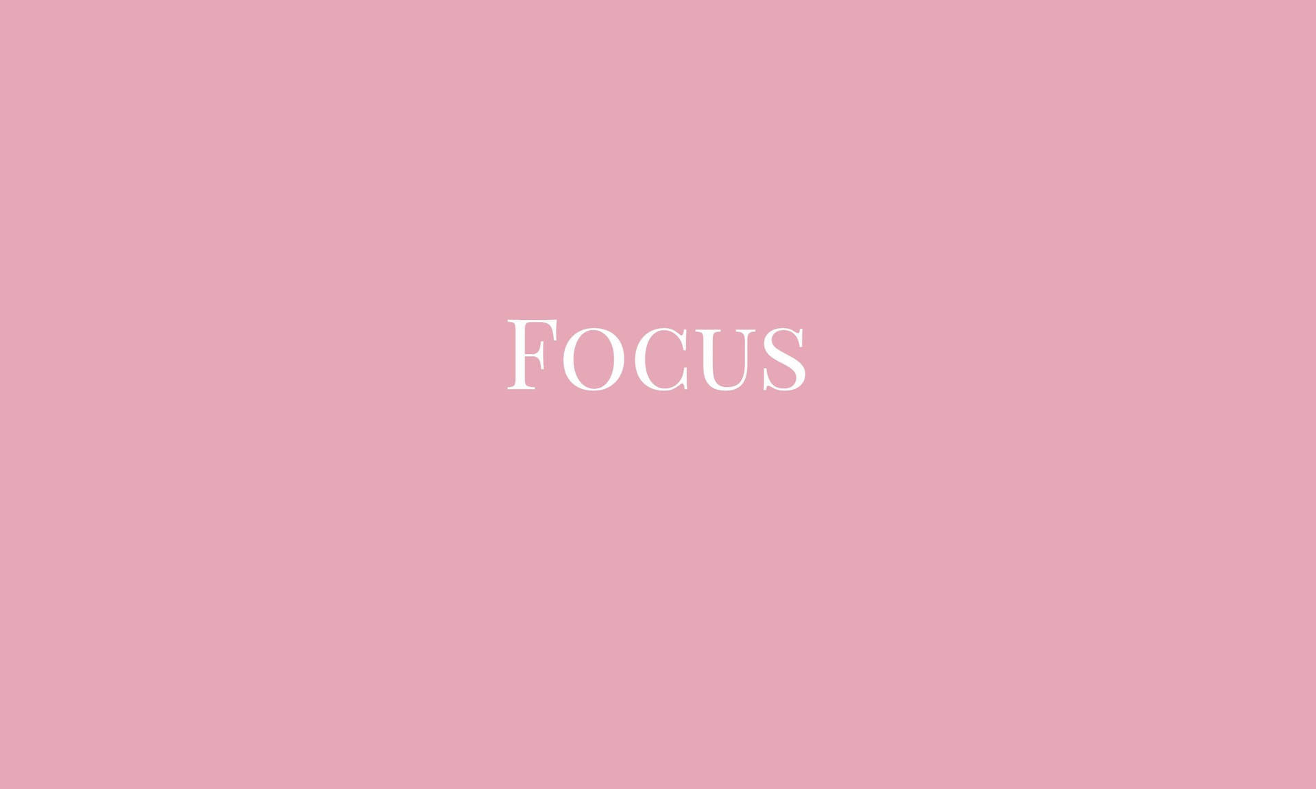 高解析度粉紅聚焦 壁紙 — 「focus」一詞以優雅的白色襯線字體居中顯示在柔和的粉紅色背景上。