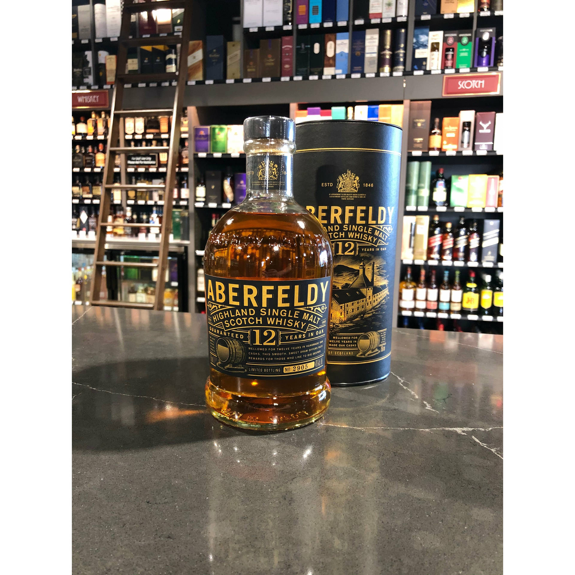 Aberfeldy 12年威士忌酒瓶和禮盒放在酒類商店的大理石檯面上。