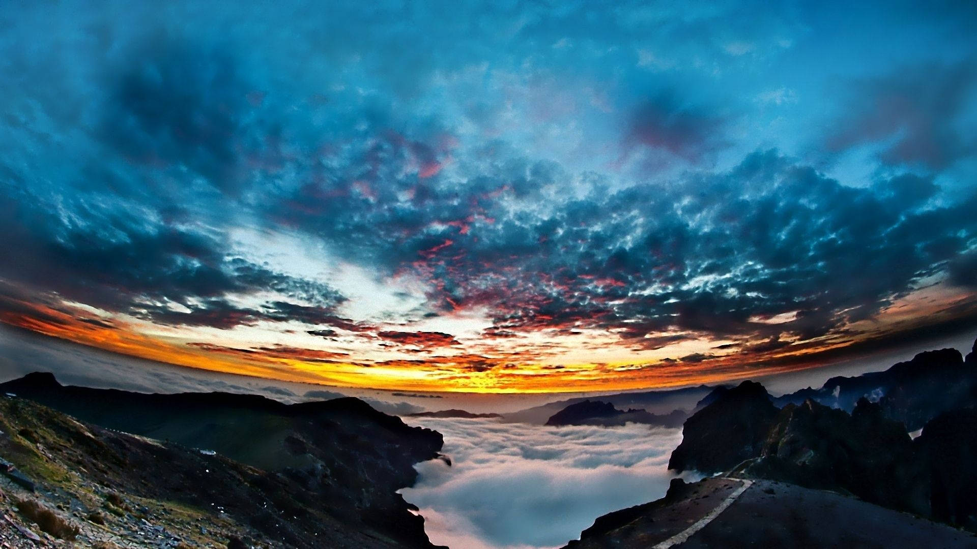 日出於山峰之上，雲層之下