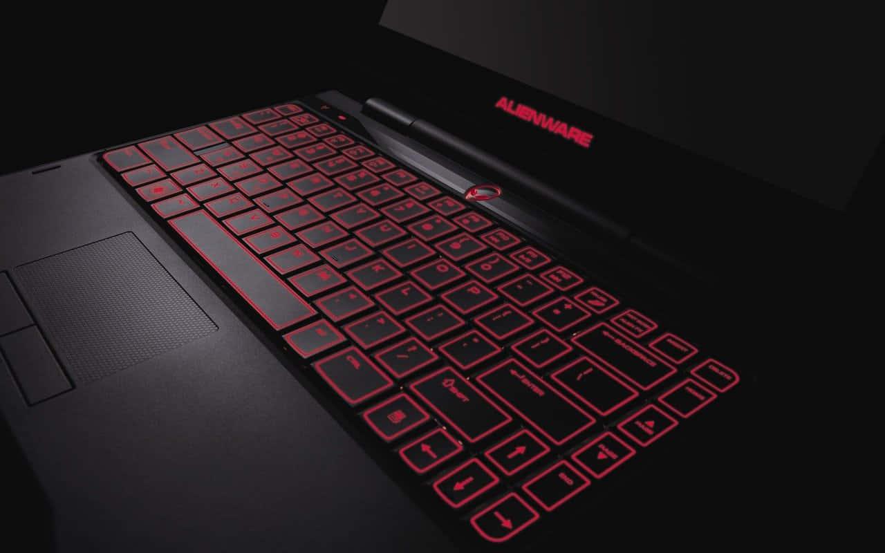 在黑暗環境中配備紅色背光鍵盤的Alienware遊戲筆記型電腦