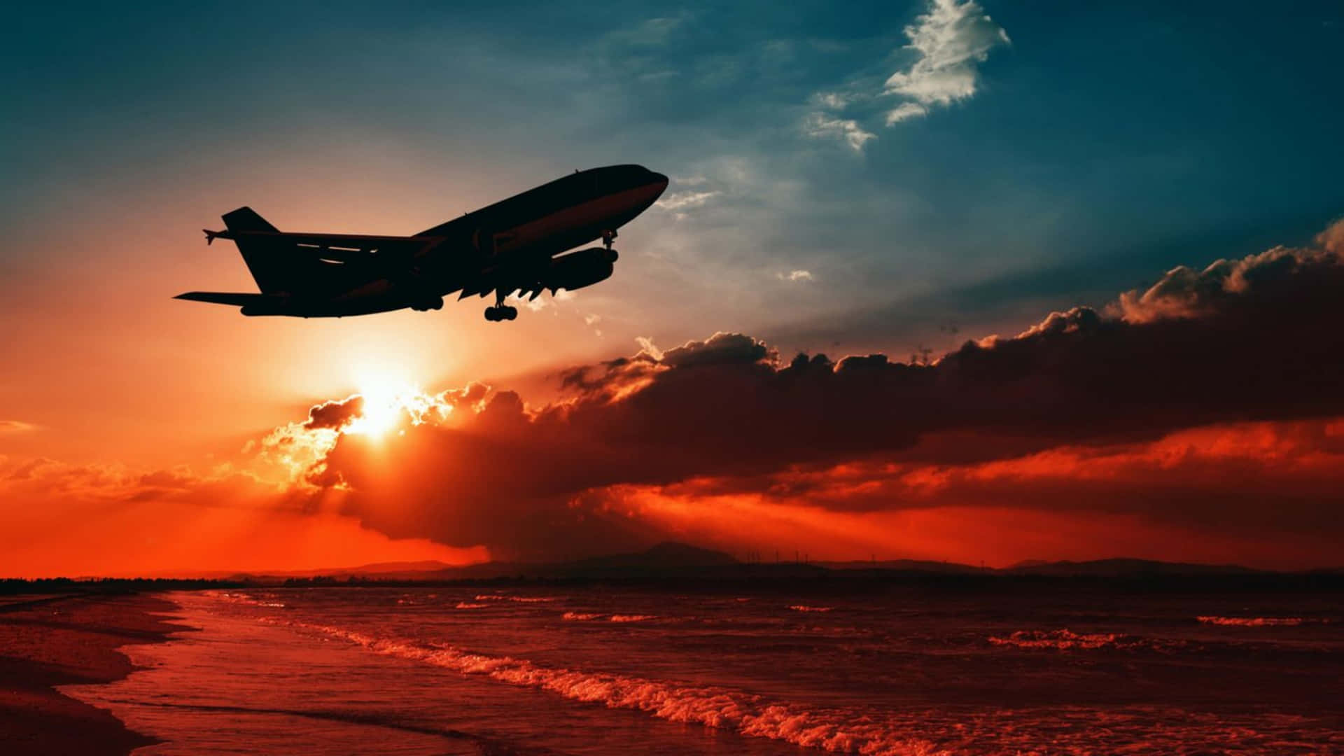 飛機在夕陽下從沙灘起飛，天空呈現橙色和藍色。