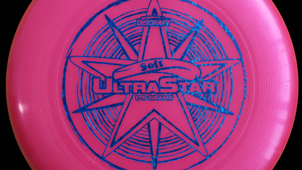 粉紅色Discraft UltraStar飛盤，帶藍色星星設計