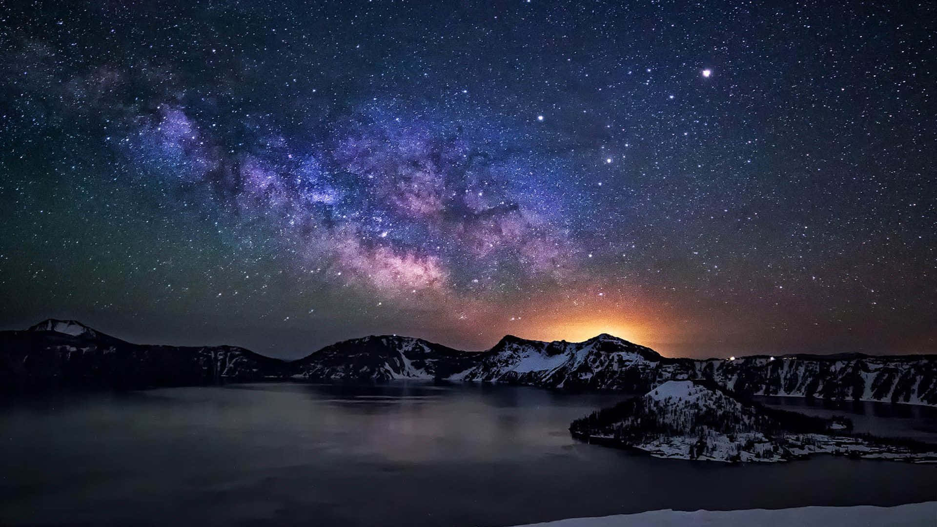 雪覆蓋的山脈和湖泊，在繁星點點的夜空和銀河下