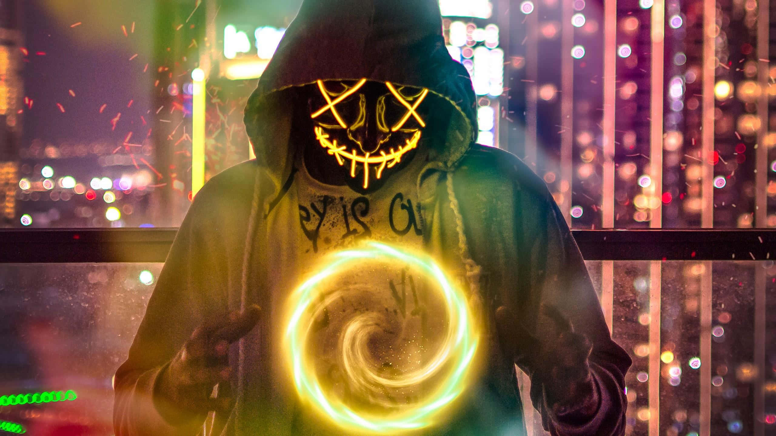 魔法面具男子創造傳送門的奇幻圖像 壁紙 — 一個戴著發光面具的兜帽身影，在霓虹燈照亮的城市夜景中，引導著一個旋轉的金色能量球。