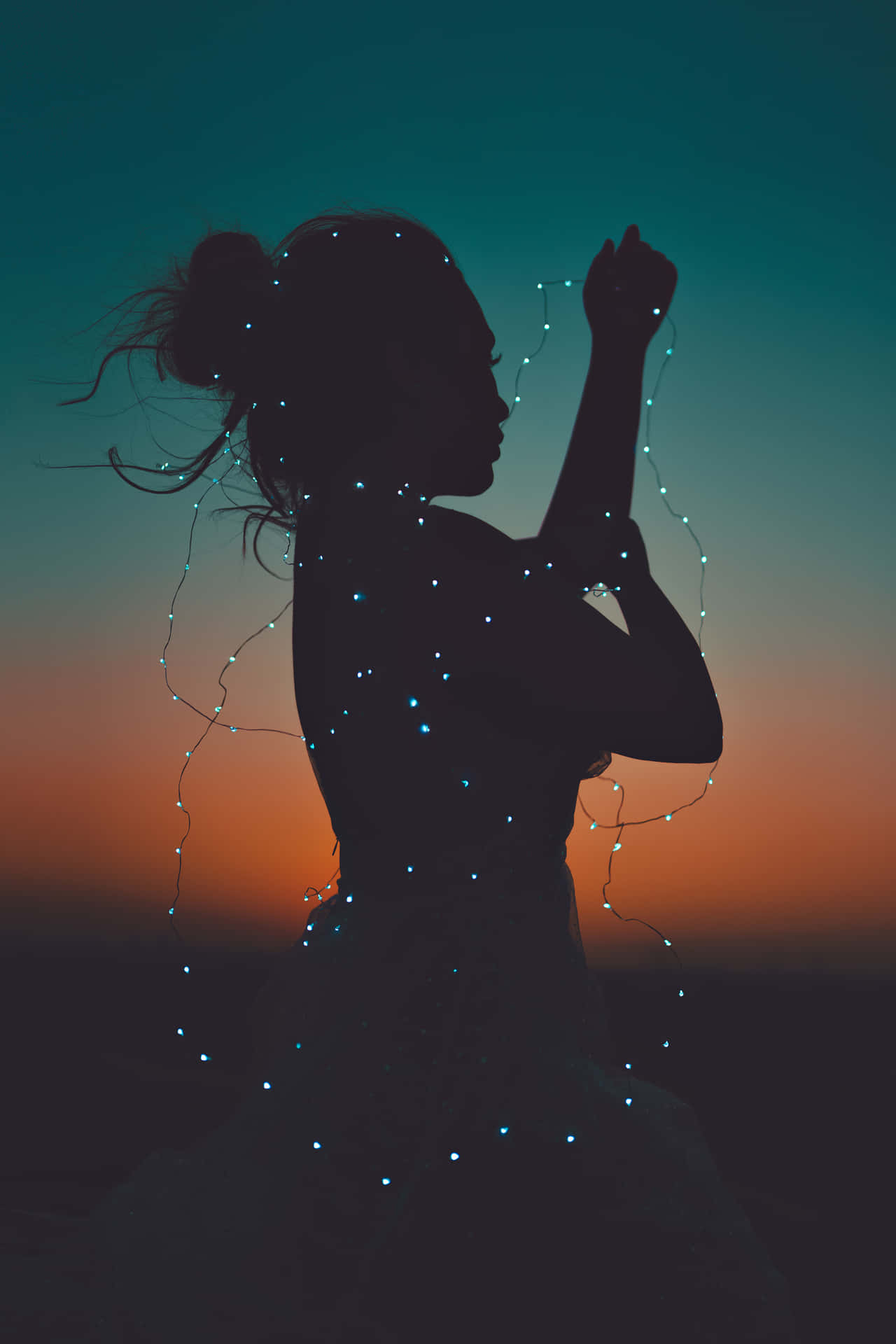 女人在黃昏時手持發光串燈
