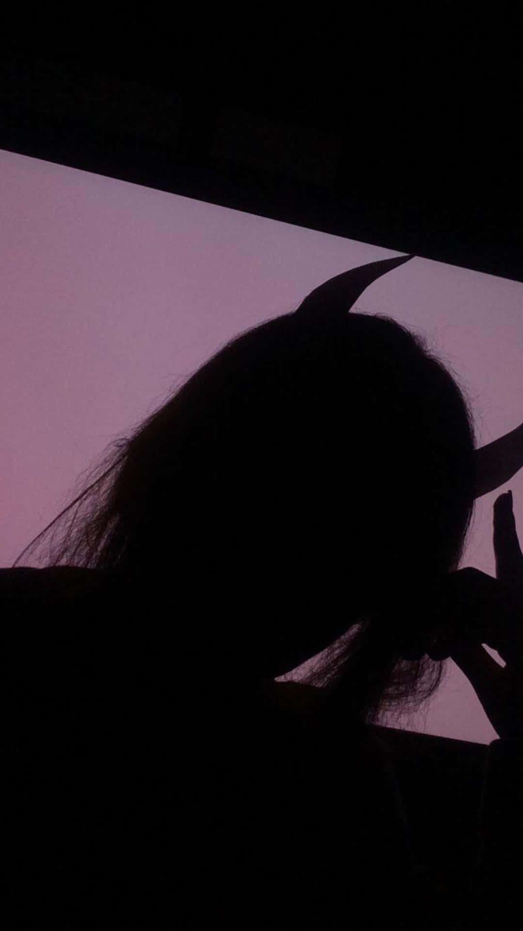 暮色中一個戴著惡魔角的人影。