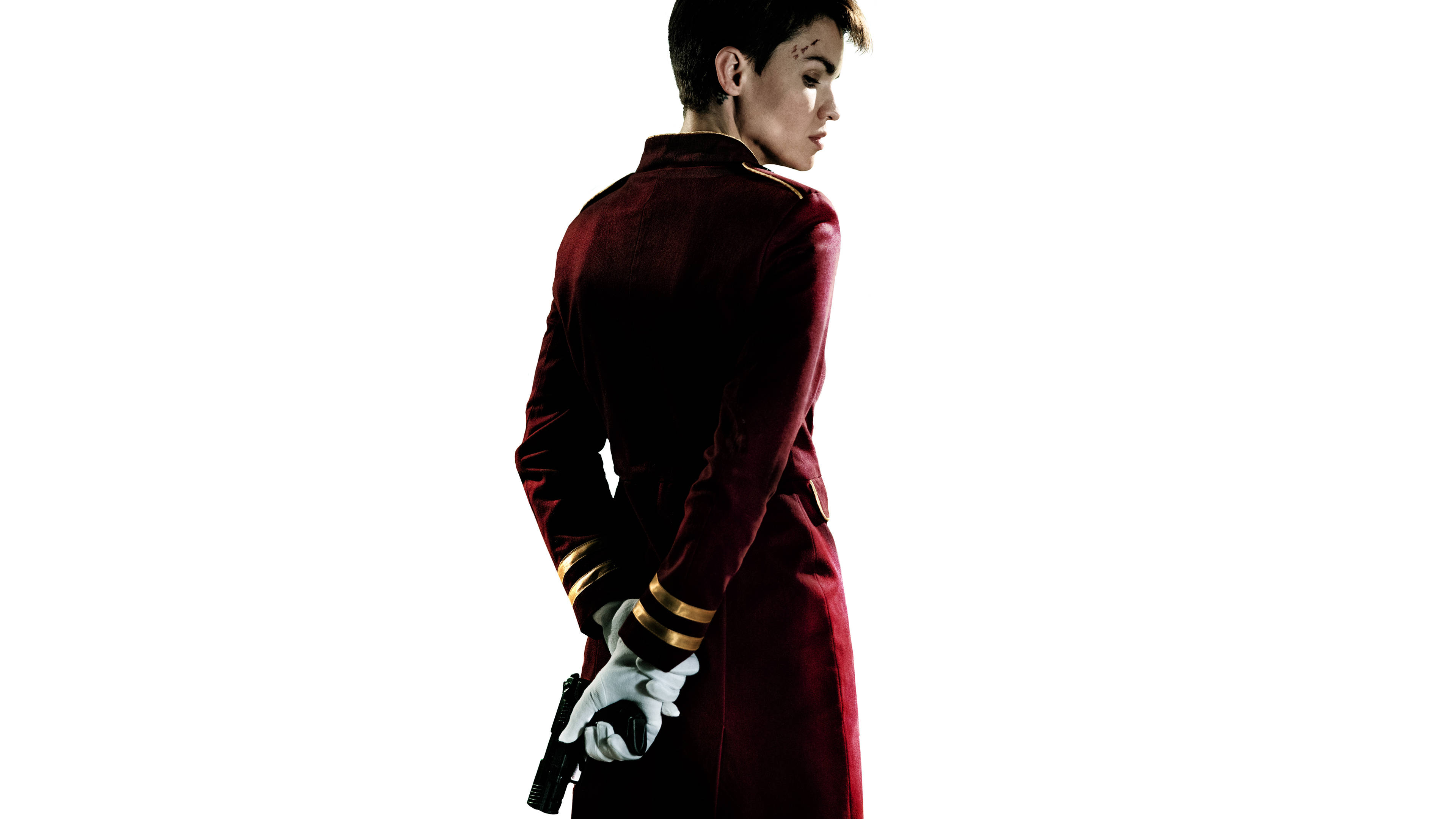 魯比·羅斯在《The Doorman》電影中 壁紙 — 一個穿著紅色天鵝絨制服、戴著白手套的人，在純白色背景前拿著槍。
