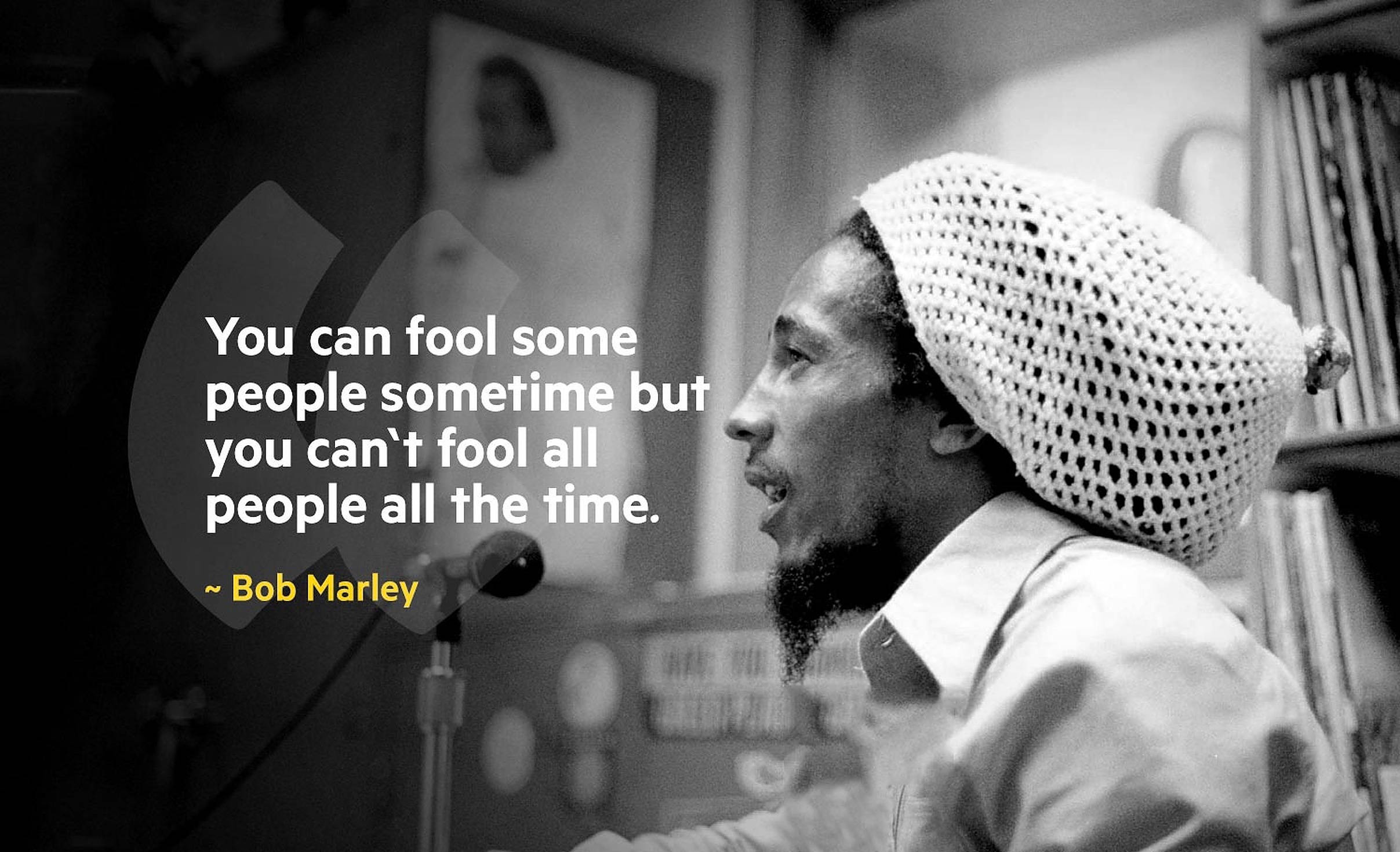 鮑伯馬利語錄灰階版 壁紙 — 黑白照片中的Bob Marley戴著鉤針編織帽對著麥克風唱歌，並疊加了引文。
