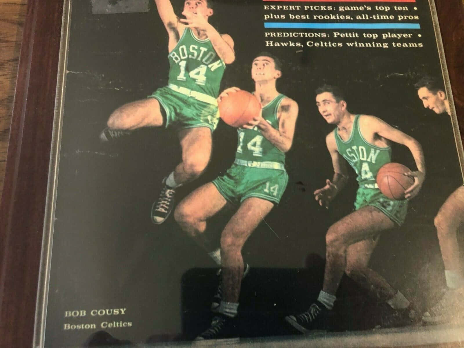 鮑勃·庫西波士頓塞爾提克隊相框照 壁紙 — 復古雜誌封面，Bob Cousy 身穿綠色波士頓塞爾特人球衣，在動態籃球比賽中騰空而起。