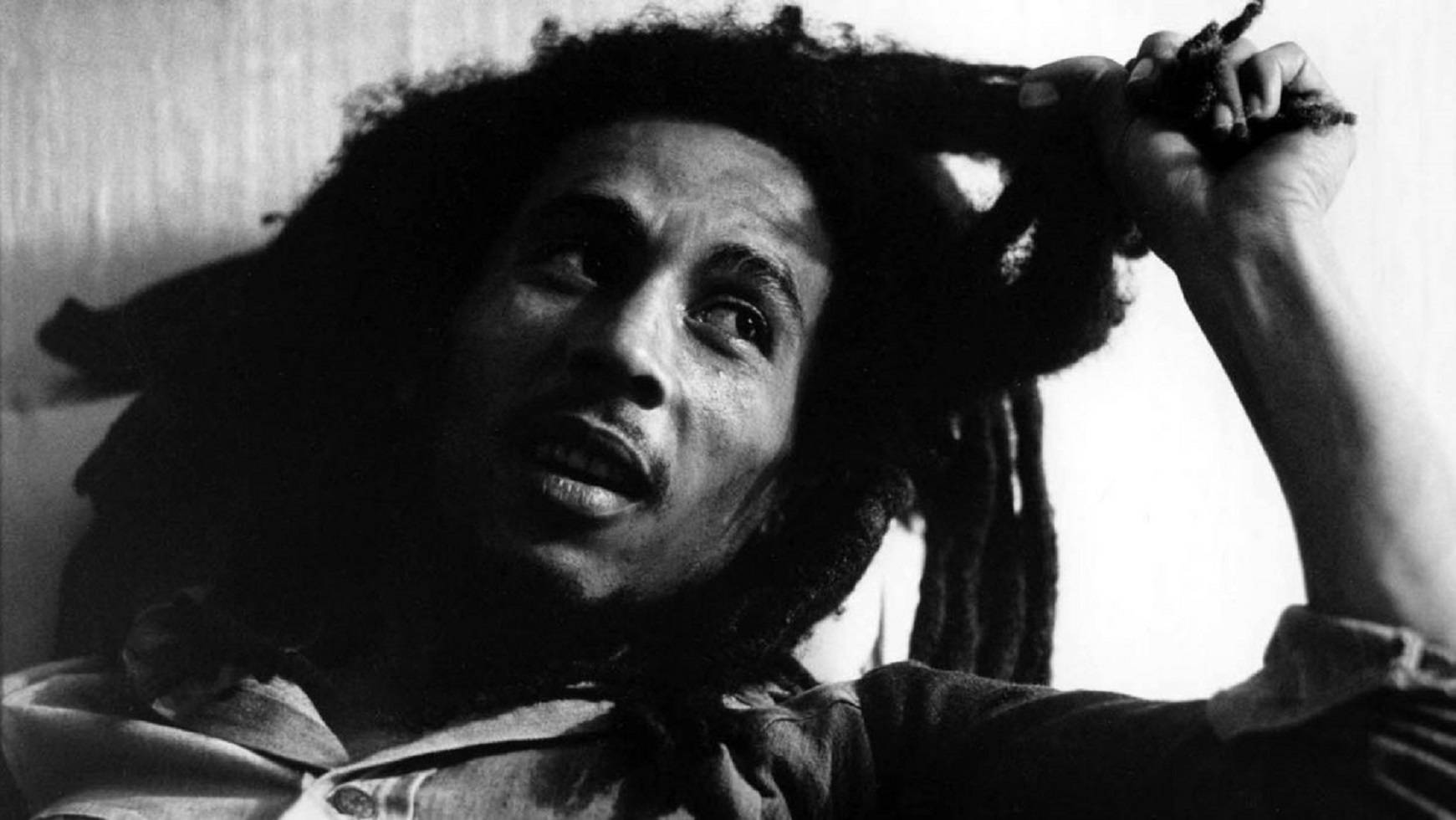 Bob Marley 向上凝視，表情強烈，手抓著他的辮子