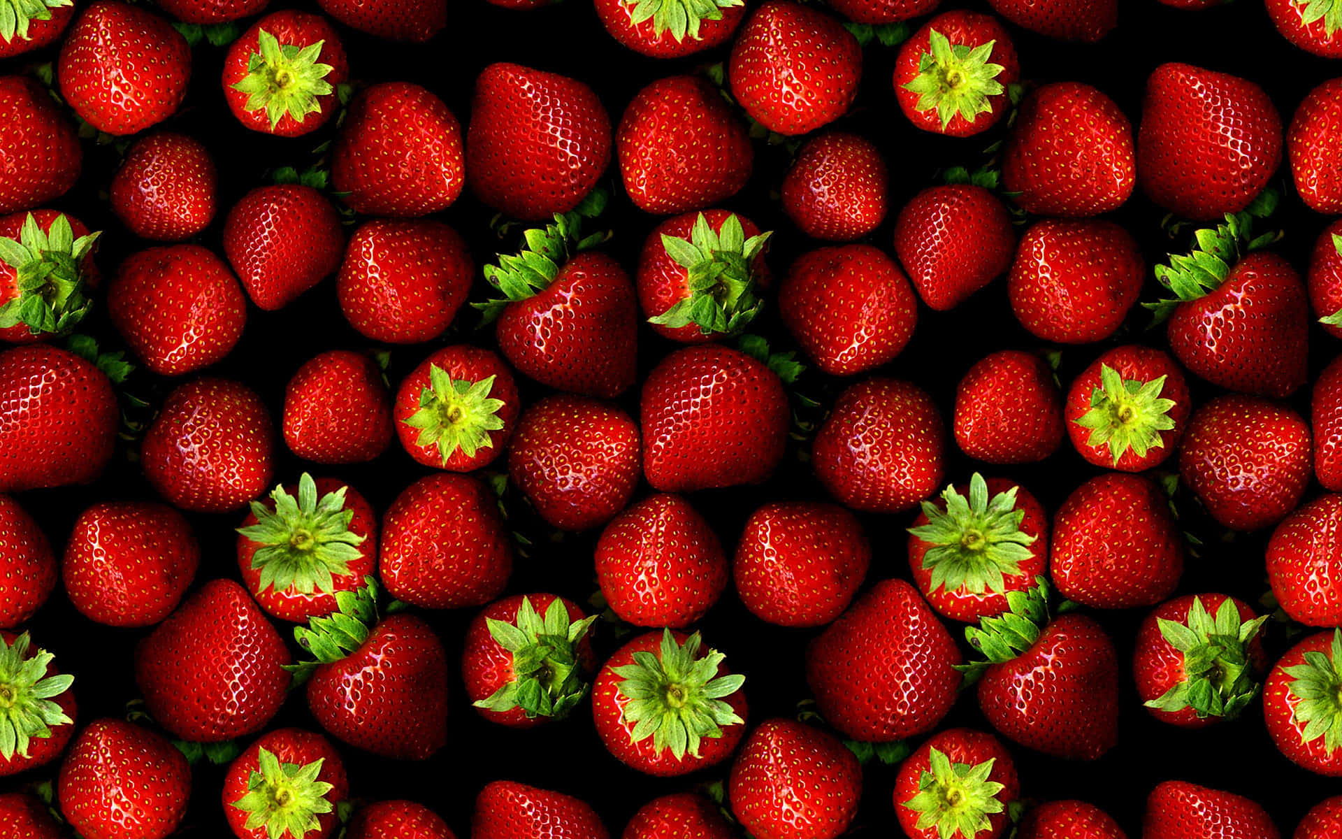 Cute Strawberry 桌布 壁紙 — 鮮紅士多啤梨配綠色頂部，密集排列在黑色背景上。