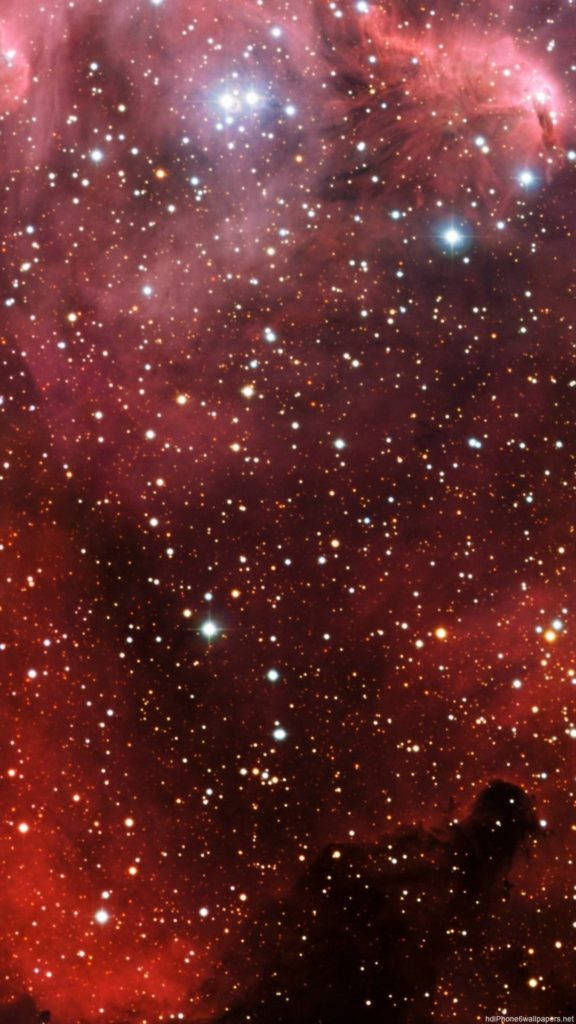 在深空中充滿無數星星的鮮豔紅色星雲。