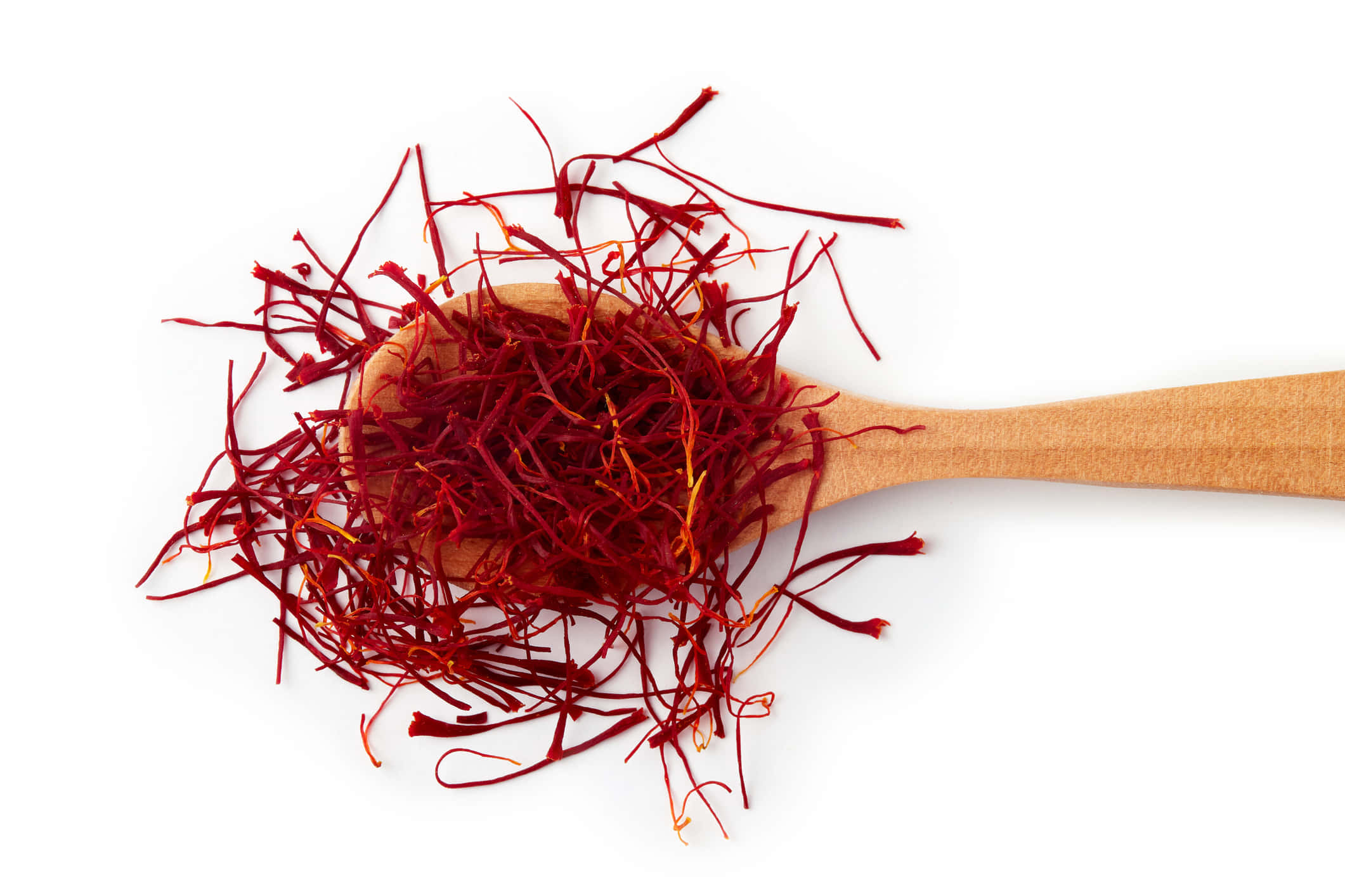 Saffron 桌布 壁紙 — 鮮紅的藏紅花絲從木勺中溢出，映襯在純白的背景上。