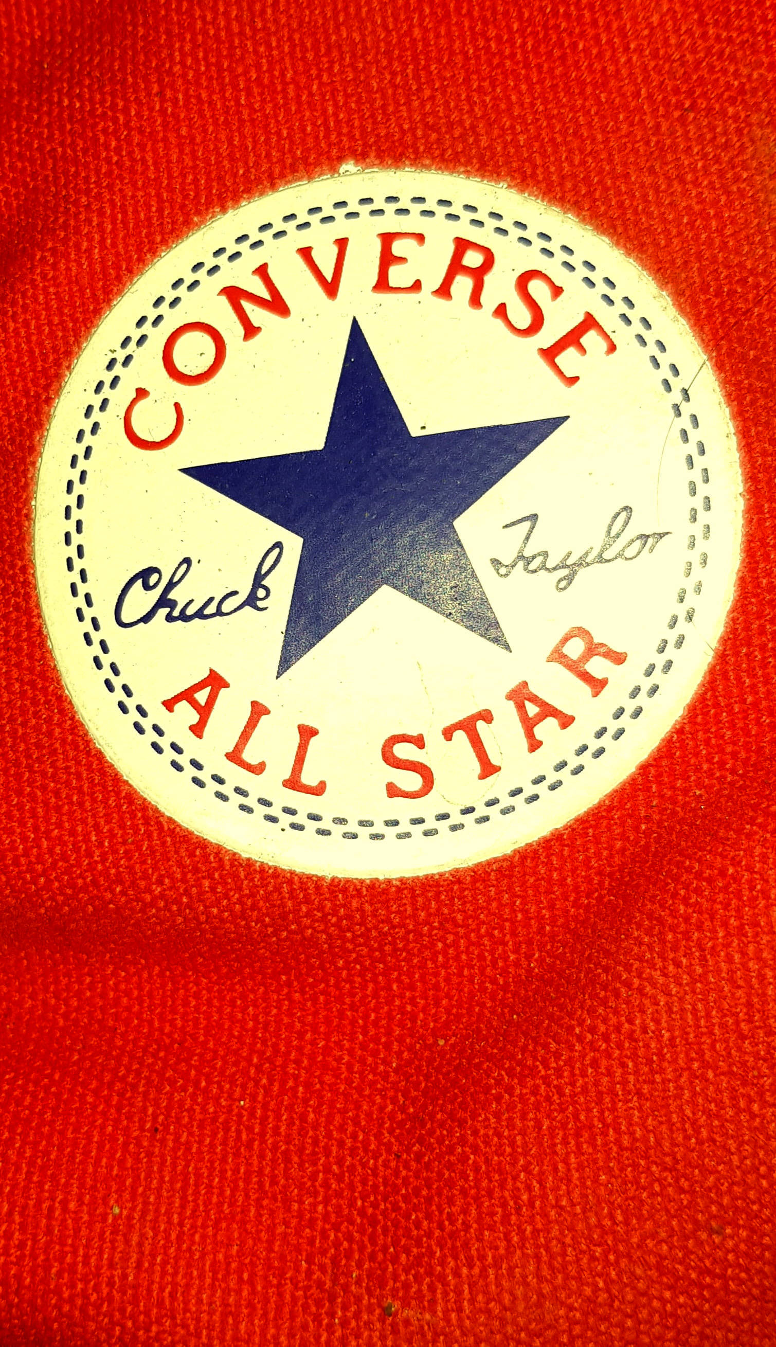 鮮豔Converse標誌 壁紙 — 經典 Converse All Star 標誌特寫，位於鮮紅色帆布上，帶有藍色星星和紅色文字。