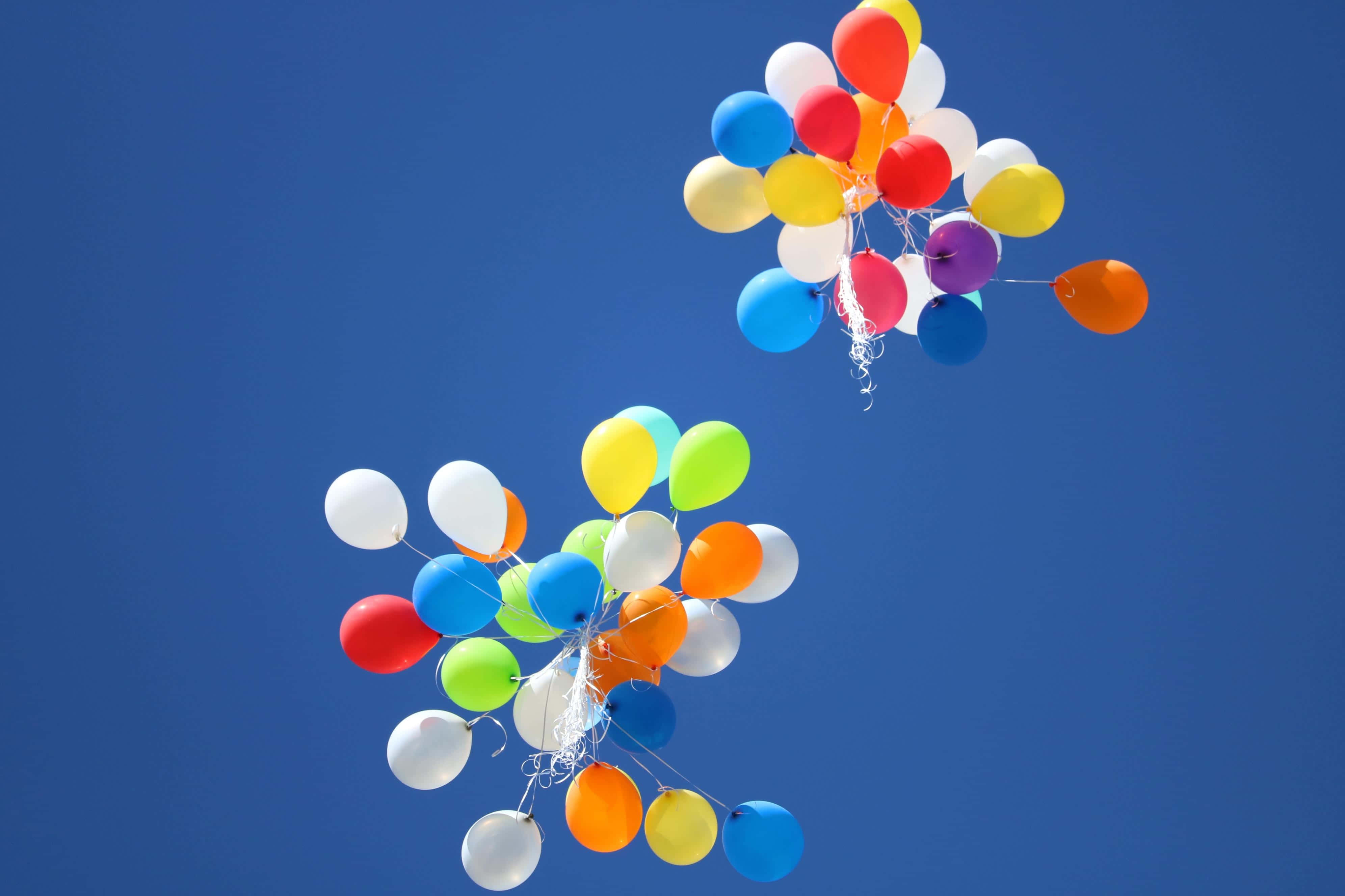 Balloon 桌布 壁紙 — 鮮豔多彩的氣球在晴朗的日子裡，歡快地漂浮在清澈的深藍色天空上。