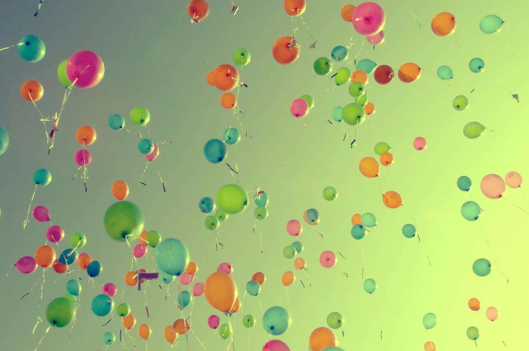Balloon 桌布 壁紙 — 鮮豔多彩的氣球在柔和漸變的天空中向上飄浮，天空閃耀著粉綠色和藍色調。