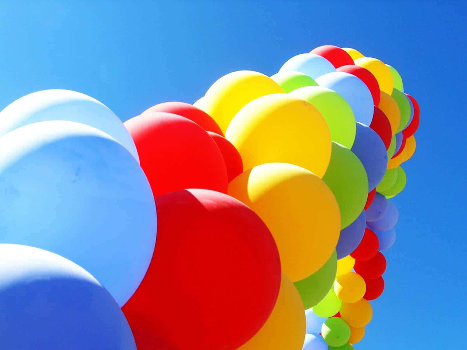 Balloon 桌布 壁紙 — 鮮豔多彩的氣球簇在晴朗的藍天下漂浮於明媚陽光中。