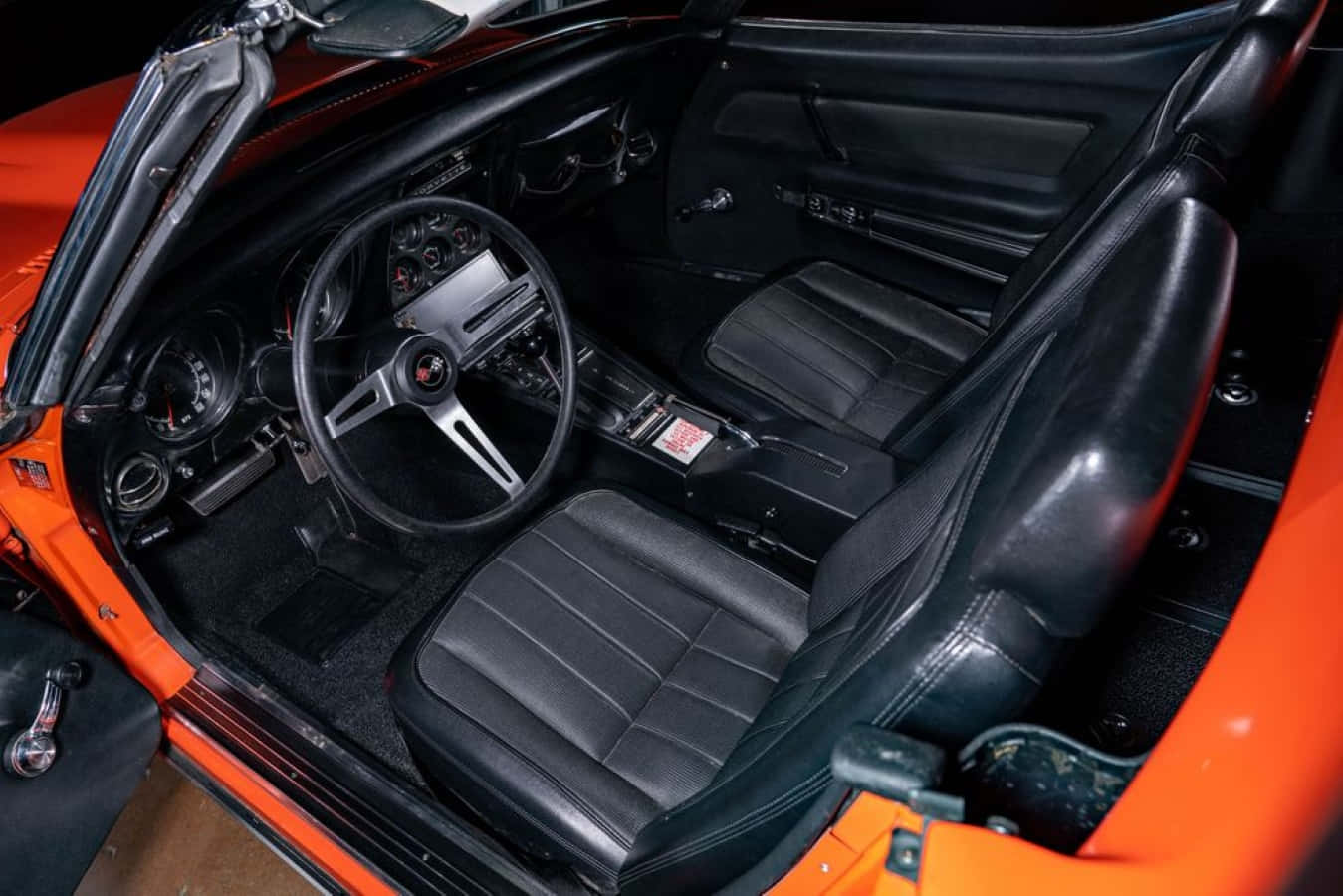 Chevrolet Corvette Zl1 桌布 壁紙 — 鮮豔橙色經典跑車內飾，配黑色皮革座椅和復古儀表板細節。