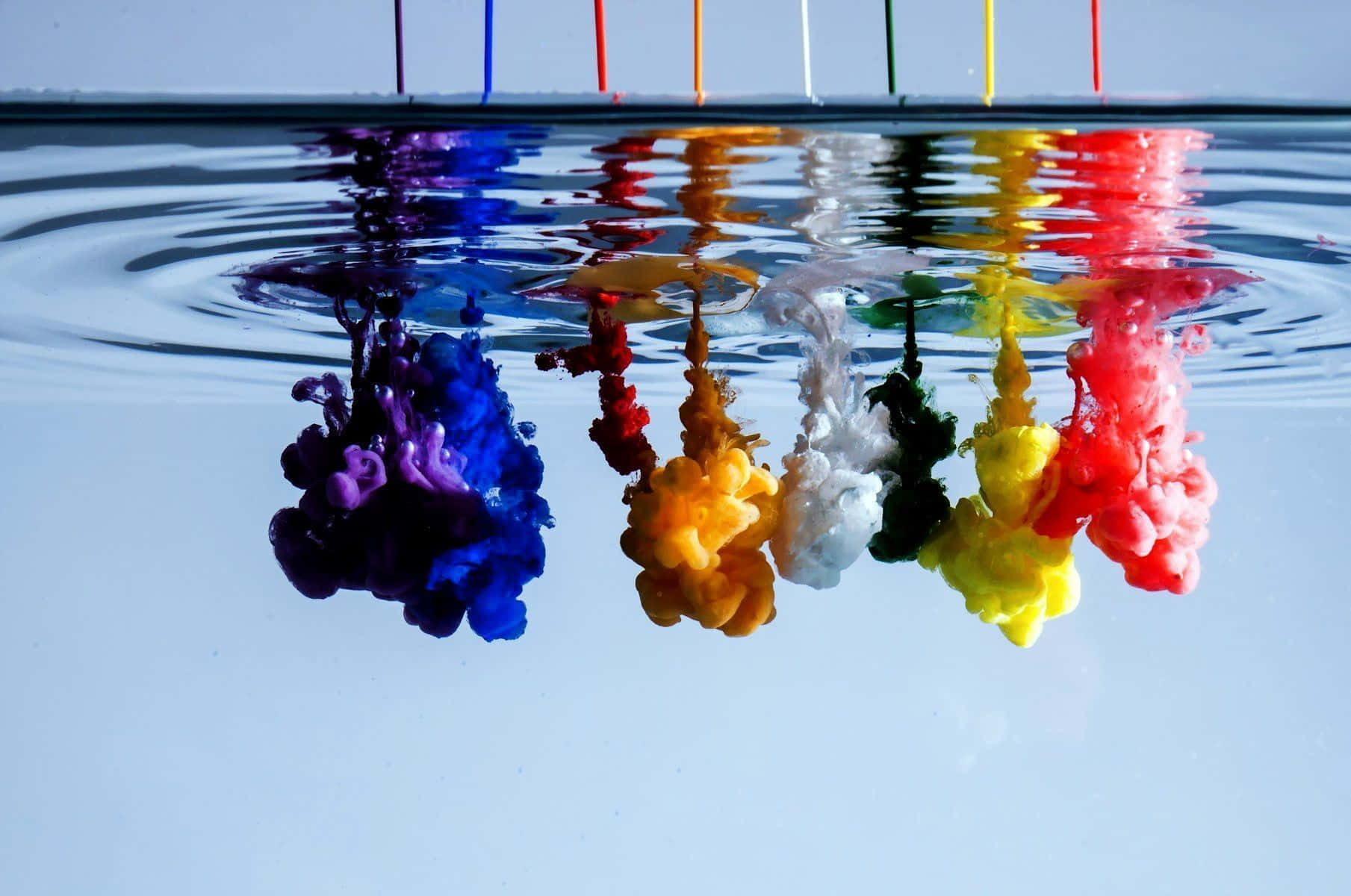 3d Water 桌布 壁紙 — 鮮豔的彩色墨水沉入清澈的水中，在水面形成旋轉的彩虹倒影。