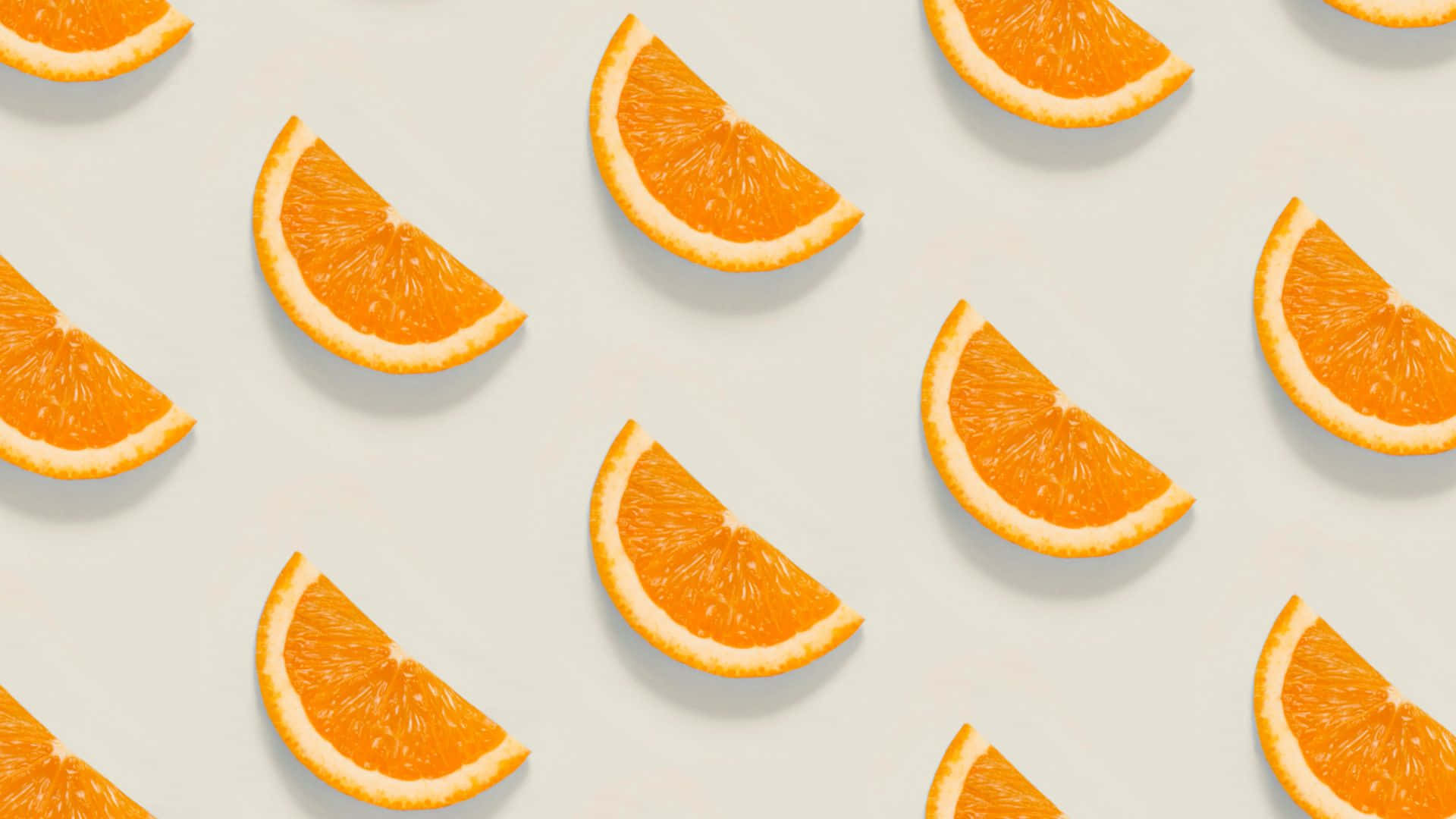 Cute Orange 桌布 壁紙 — 鮮豔的橙片以乾淨的重複圖案排列在柔和的米白色背景上。