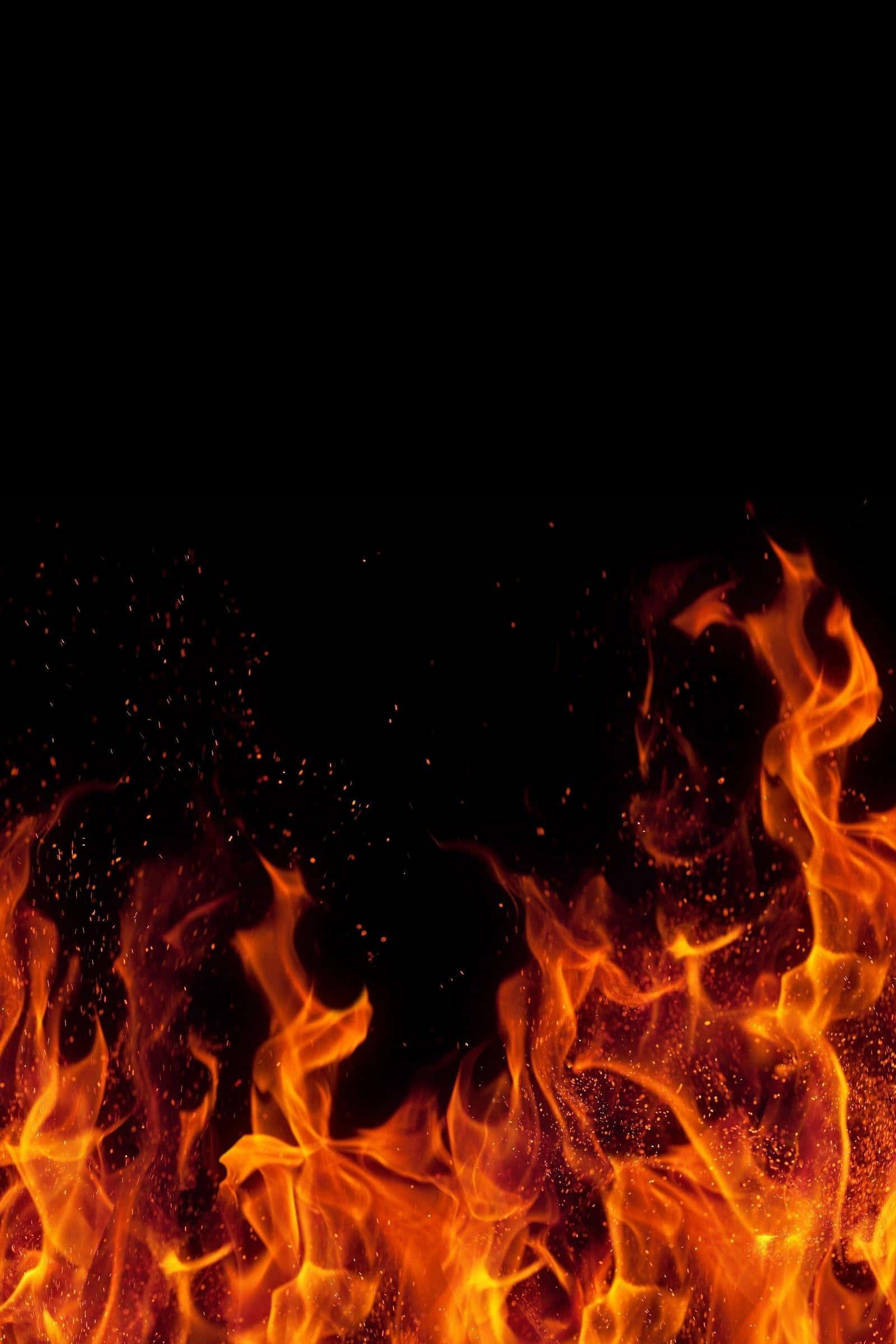 Cozy Fire 桌布 壁紙 — 鮮豔的橙色和黃色火焰在純黑背景上猛烈升騰，發光的火星在空中飄浮。