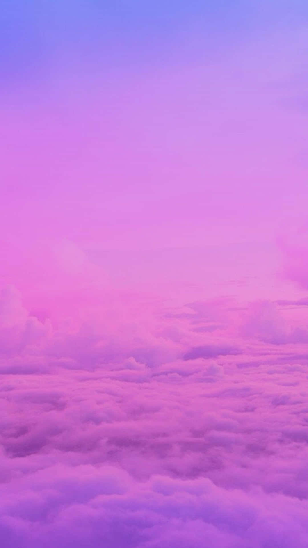 粉紅和紫色雲彩在漸變的天空下漂浮於日落時分。