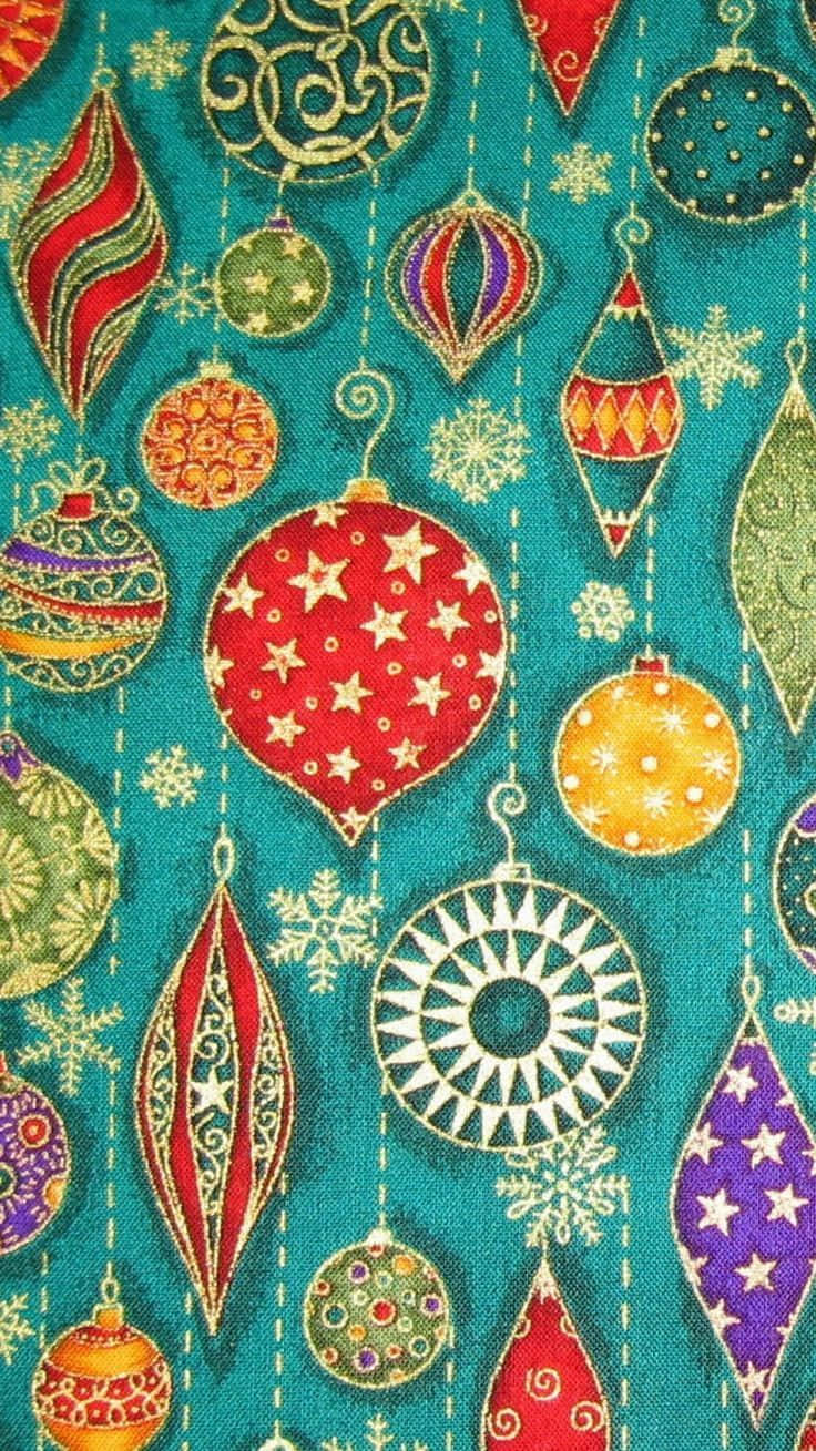 Boho Christmas 桌布 壁紙 — 鮮豔的紅色、金色和紫色聖誕裝飾品掛在帶有雪花圖案的青綠色布料背景上。