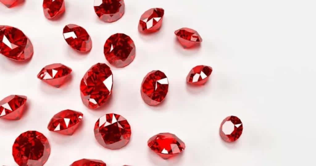 Red Diamond 桌布 壁紙 — 鮮豔的紅色寶石帶有鋒利的切割面，散落在潔白的表面上反射光線。