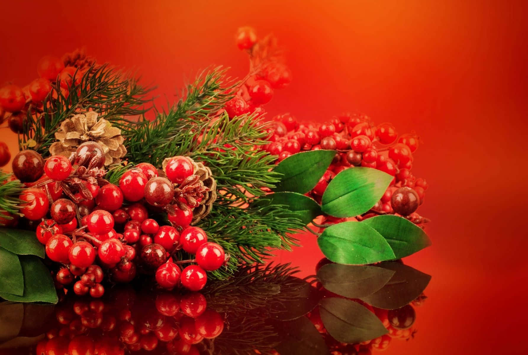 Cherry 桌布 壁紙 — 鮮豔的紅色漿果、松果和綠葉排列在光滑的黑色表面上，背景是溫暖的橙色漸變。