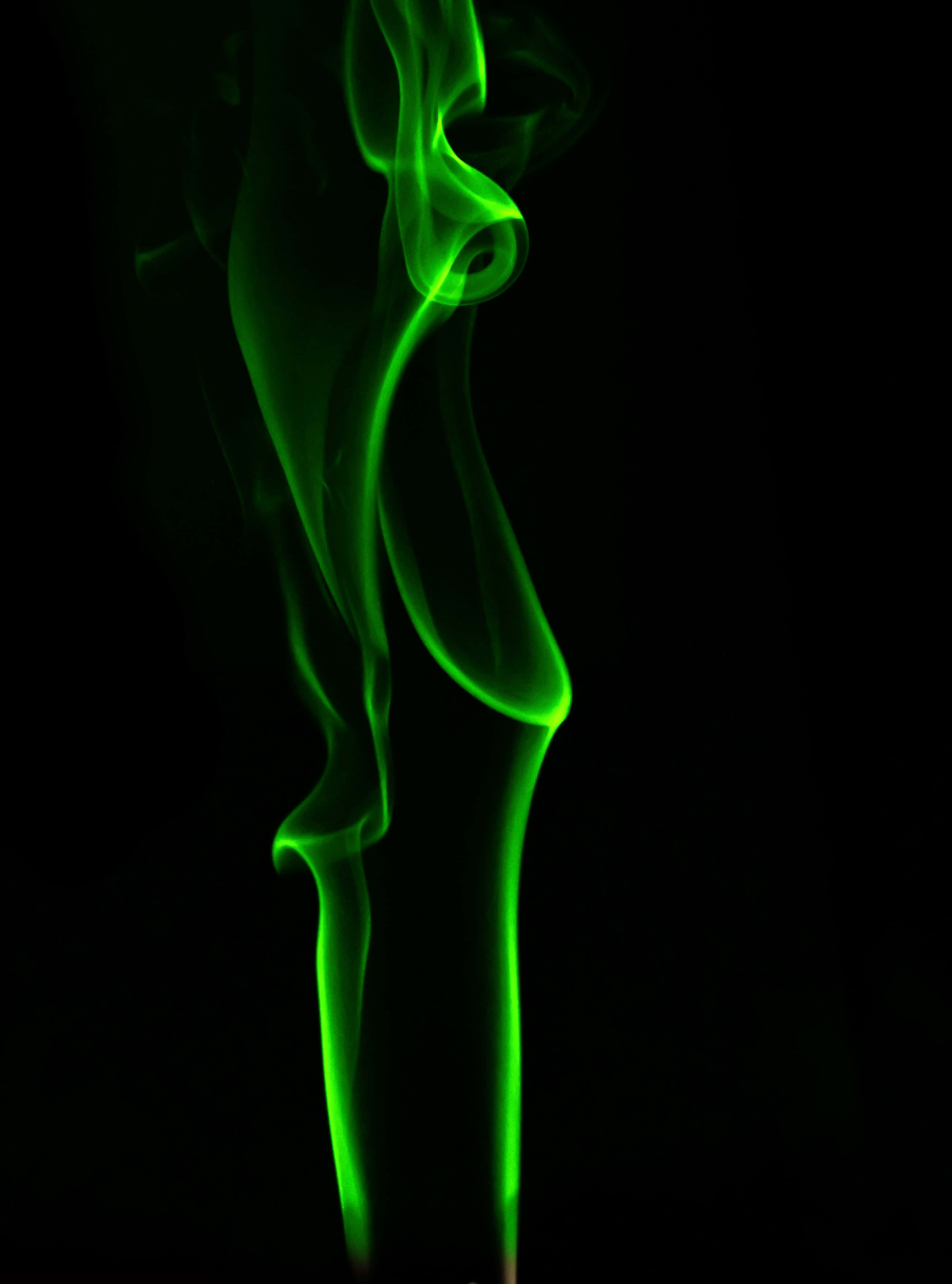 Green Smoke 桌布 壁紙 — 鮮豔的綠色煙霧在純黑色背景上優雅地盤旋，形成迷人的抽象流動。