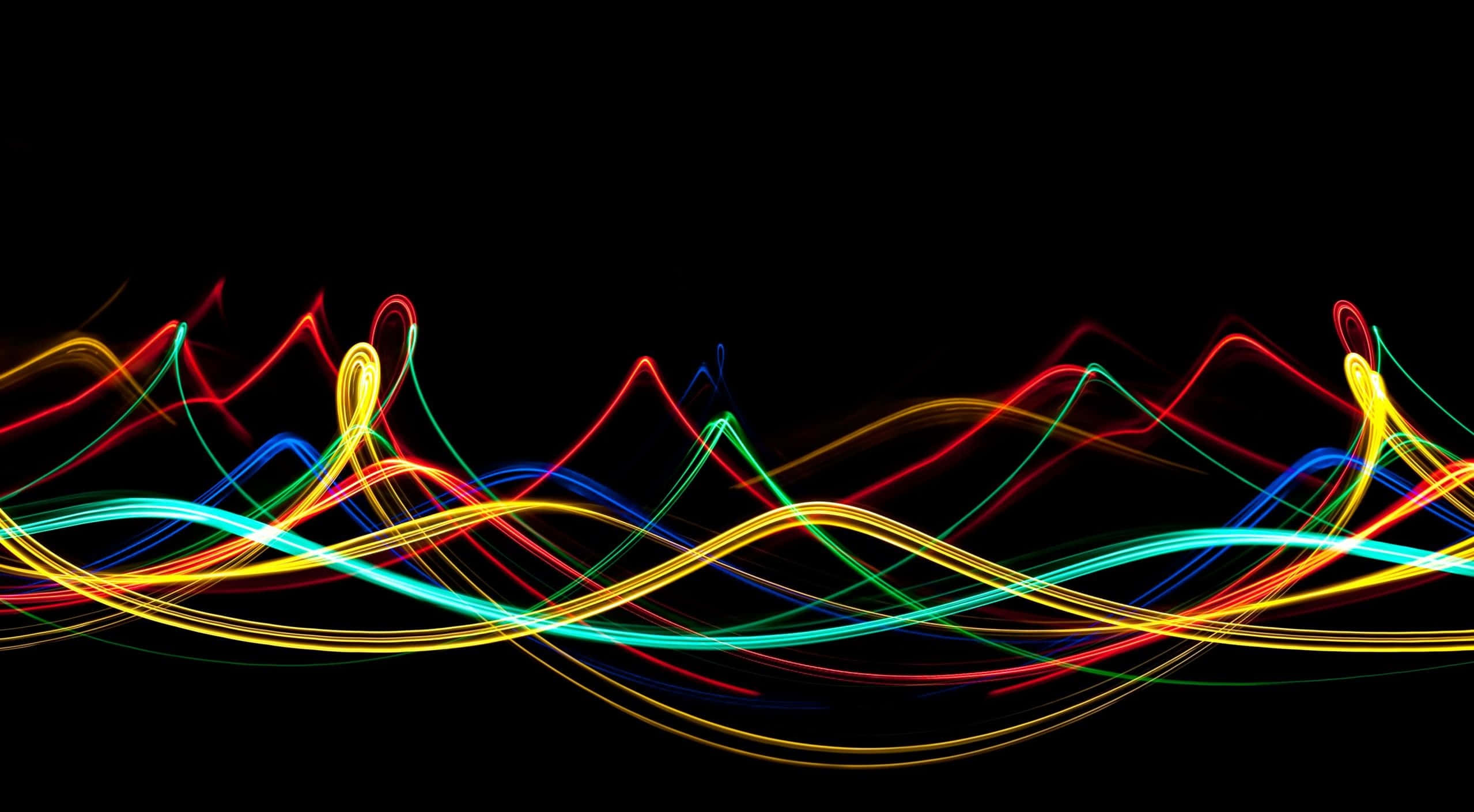 Neon Lights 桌布 壁紙 — 鮮豔的霓虹燈光軌跡以紅、黃、綠、藍色在黑色背景上旋轉，如同舞動的能量。