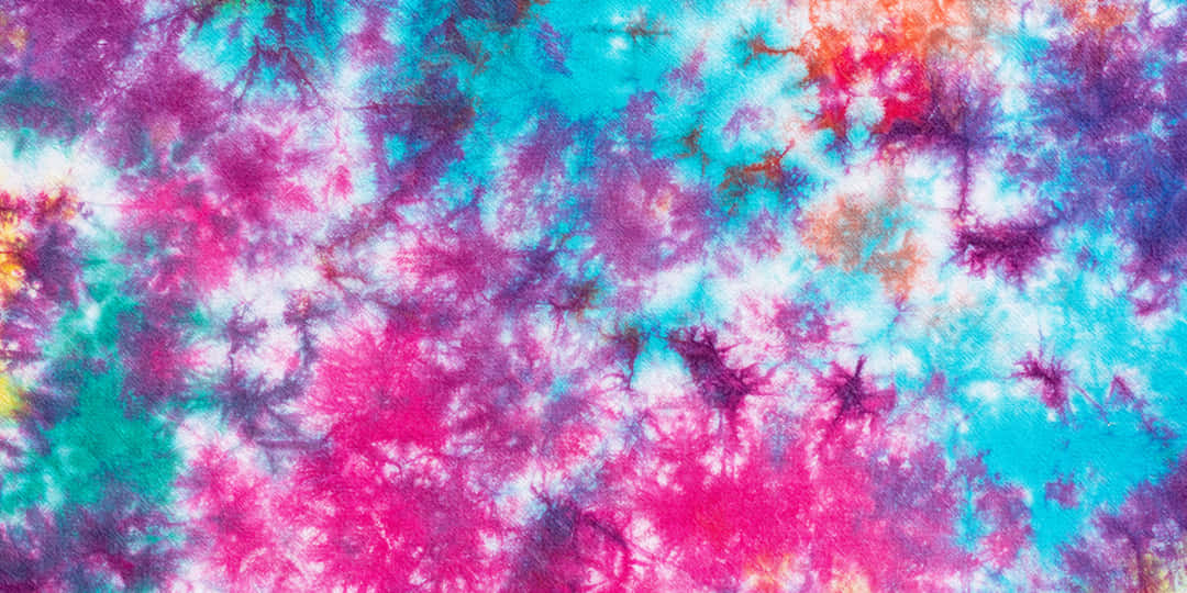 白色布料上帶有粉紅、藍綠和紫色漩渦的鮮豔紮染圖案。