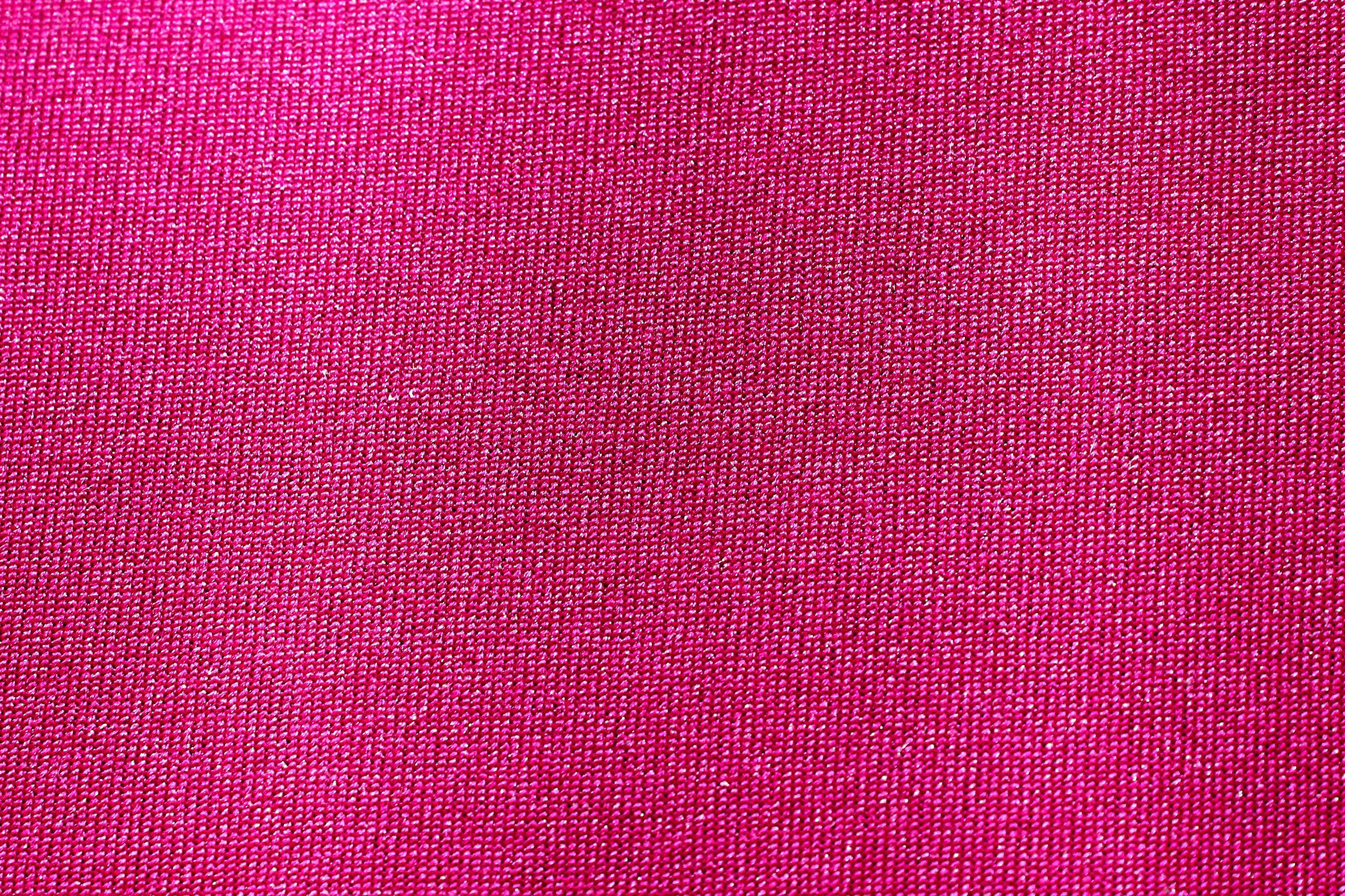 Pink Texture 桌布 壁紙 — 鮮豔粉紅色紋理布料特寫，帶有細微光澤和編織圖案。