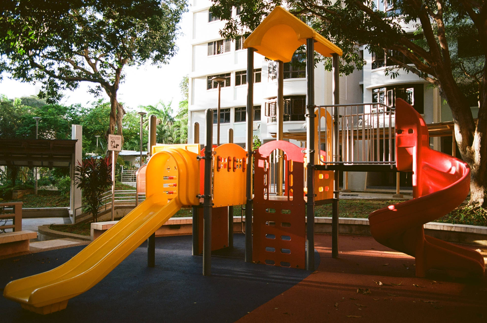 色彩繽紛的遊樂場，在明亮的陽光下，位於綠色的市區公園內。