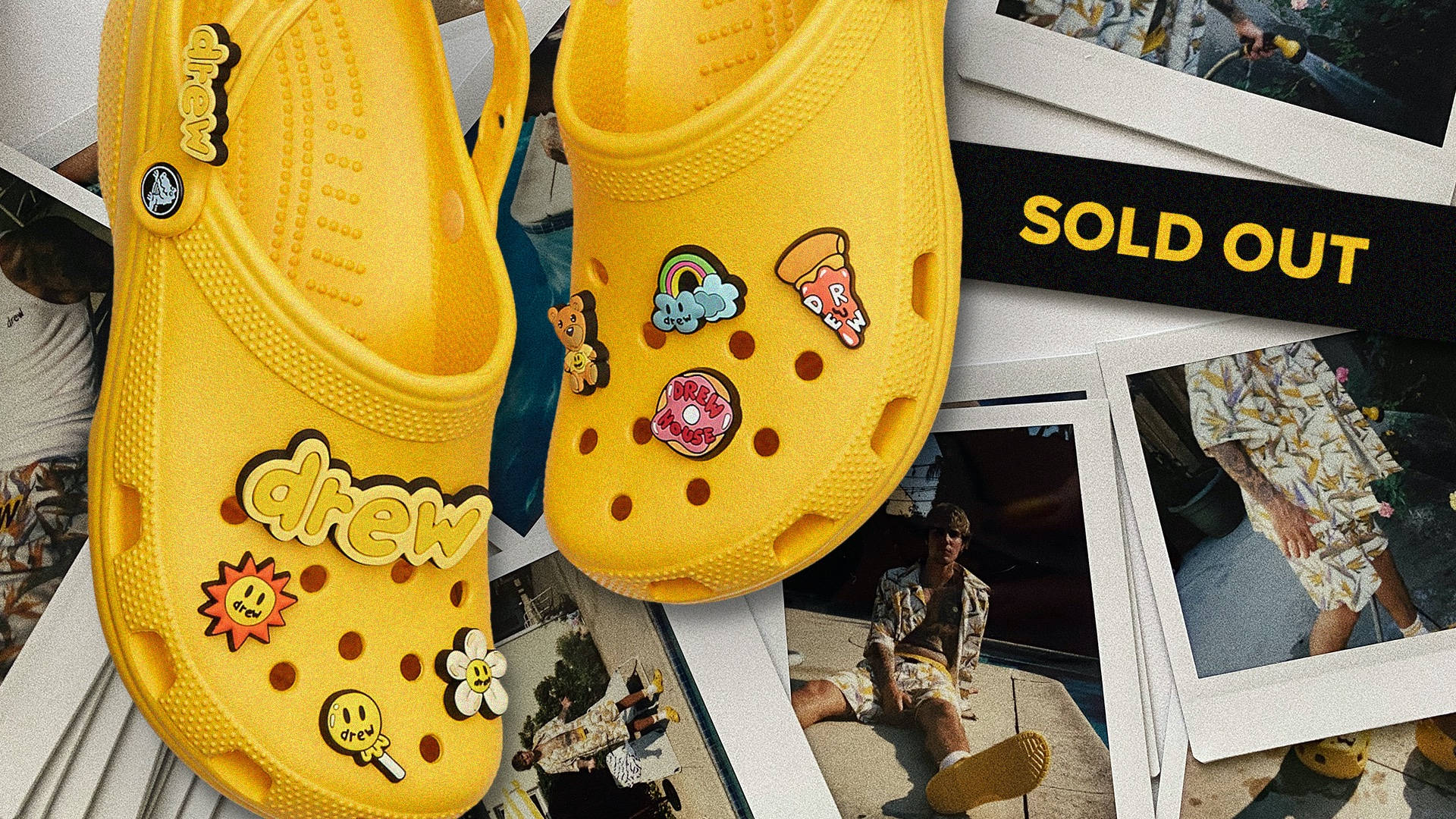 Crocs x Justin Bieber 壁紙 — 鮮黃色Crocs飾有彩色卡通補丁，放在散落的寶麗來照片和「售罄」橫幅上。