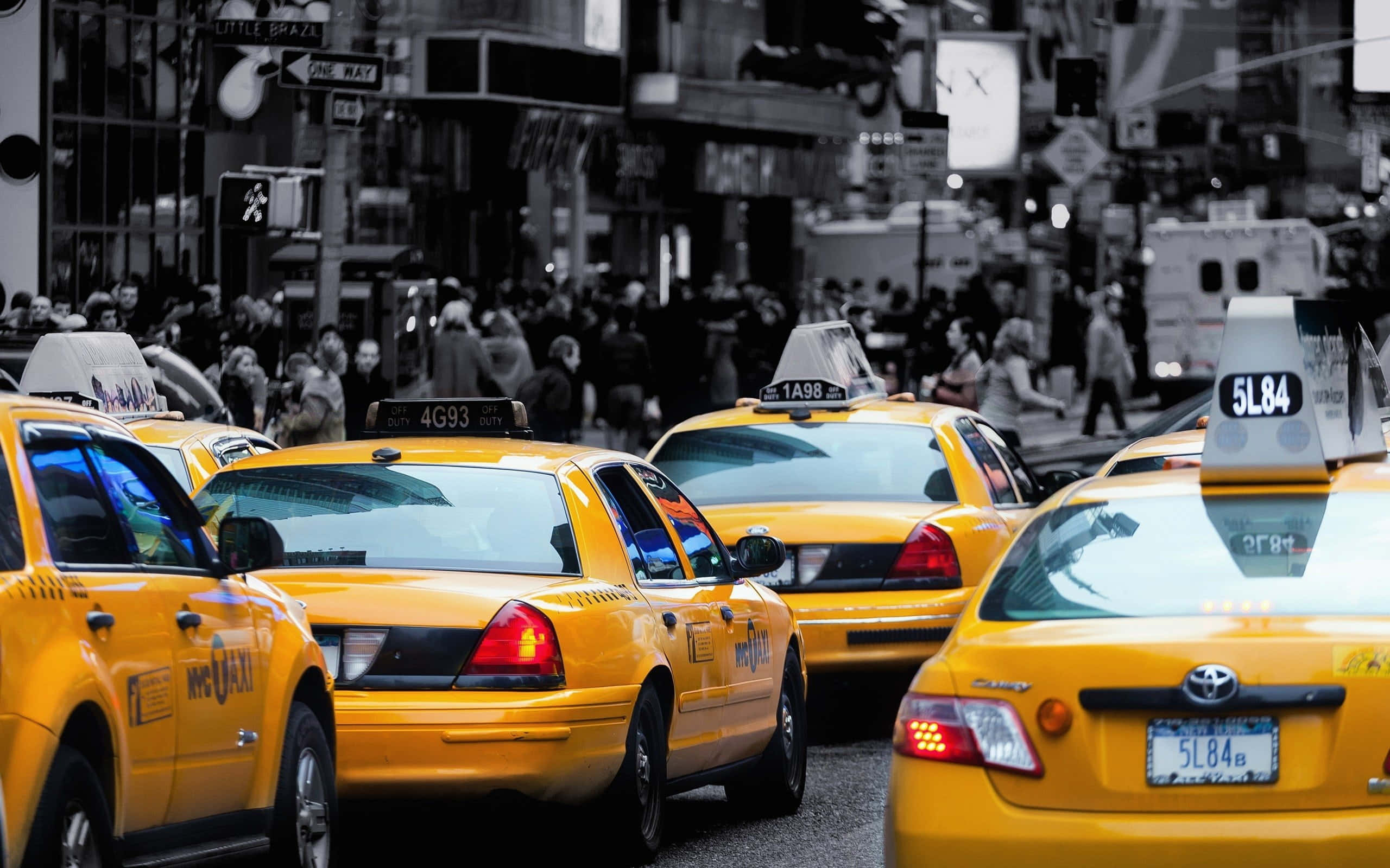 Yellow Cab 桌布 壁紙 — 鮮黃色的士排列在繁忙的紐約市街道上，背景有行人和城市建築。