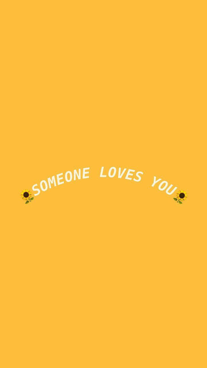 語錄 桌布 壁紙 — 鮮黃色背景上，白色文字「someone loves you」呈拱形排列在兩個向日葵表情符號之間。