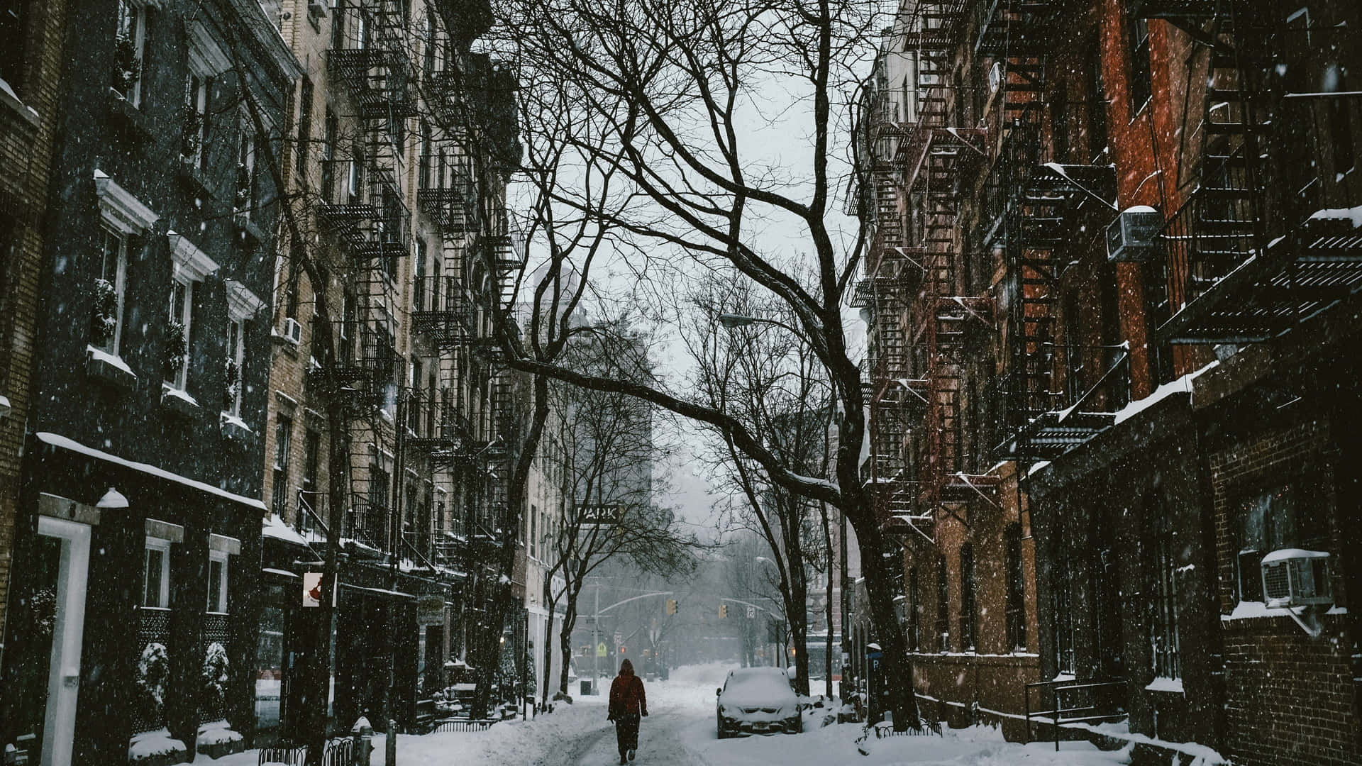 人在積雪的城市街道上行走，兩旁是磚砌建築