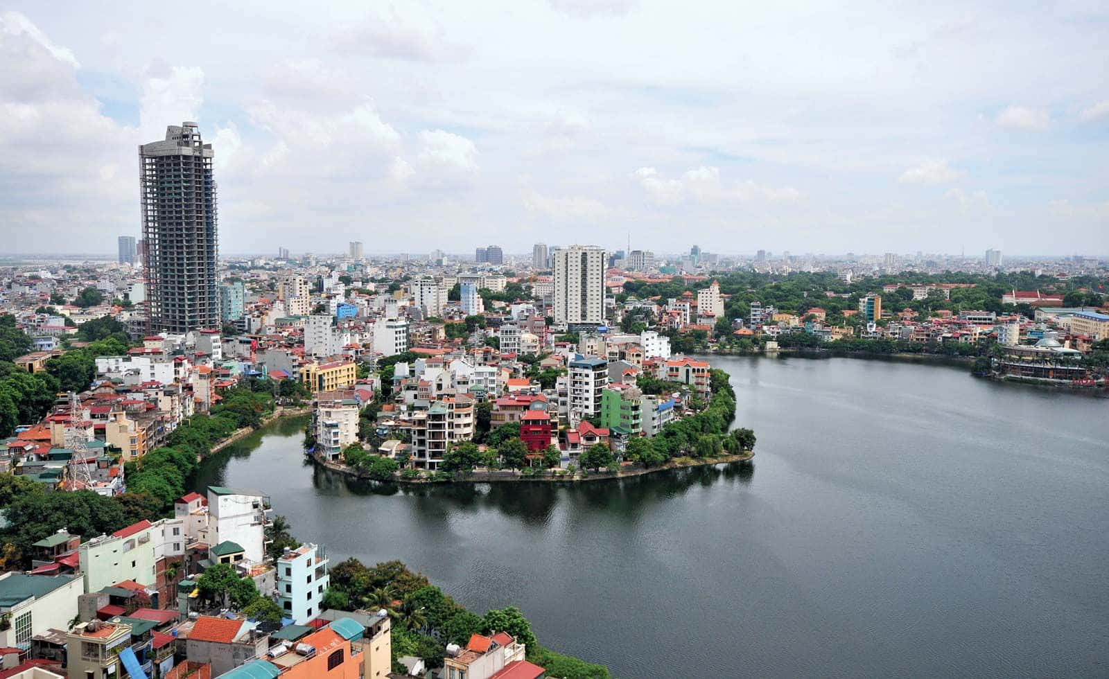 Vietnam 桌布 壁紙 — 鳥瞰繁忙的城市景觀，色彩繽紛的建築環抱著一個大湖，天空多雲。