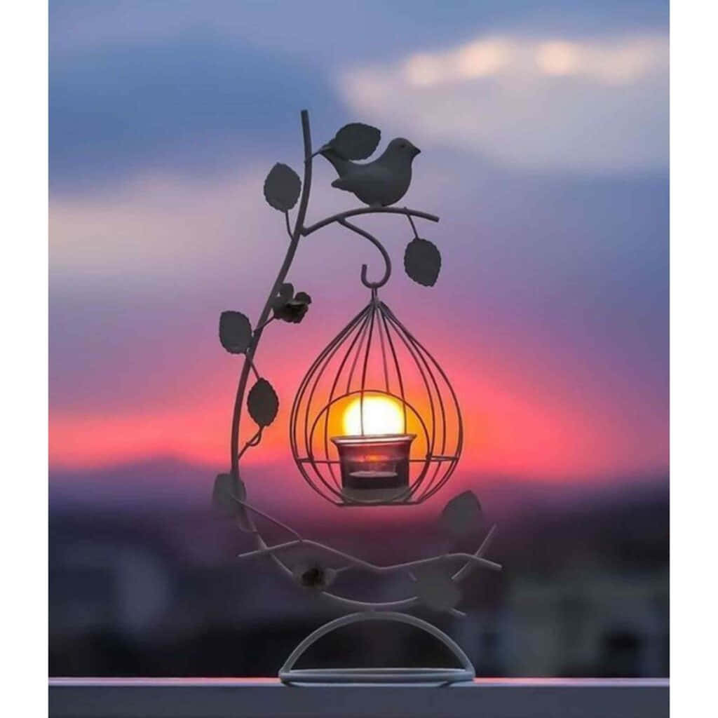 鳥籠夕陽個人頭像 壁紙 — 一隻金屬鳥棲息在藤蔓形燭台上，在帶有粉紅色和紫色色調的暮色天空中溫暖地發光。