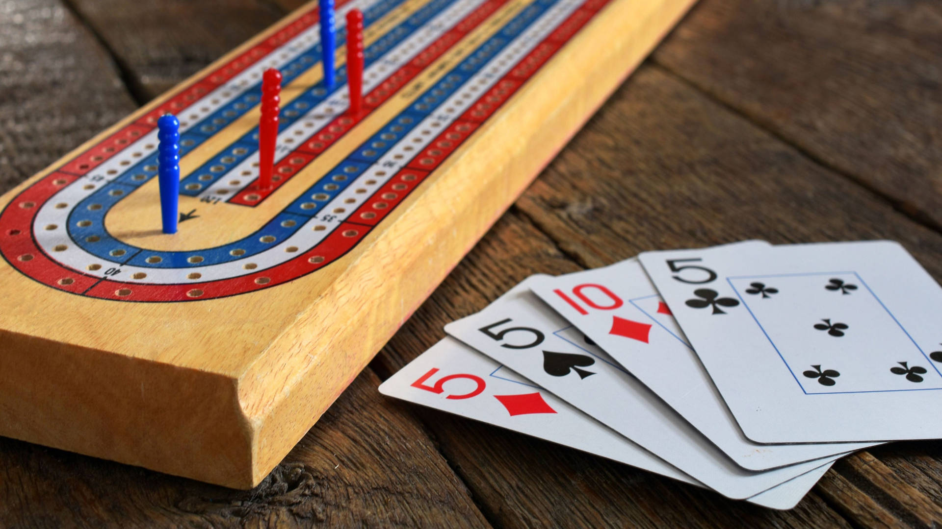 克里比奇棋盤、棋釘和撲克牌放在木質表面上。