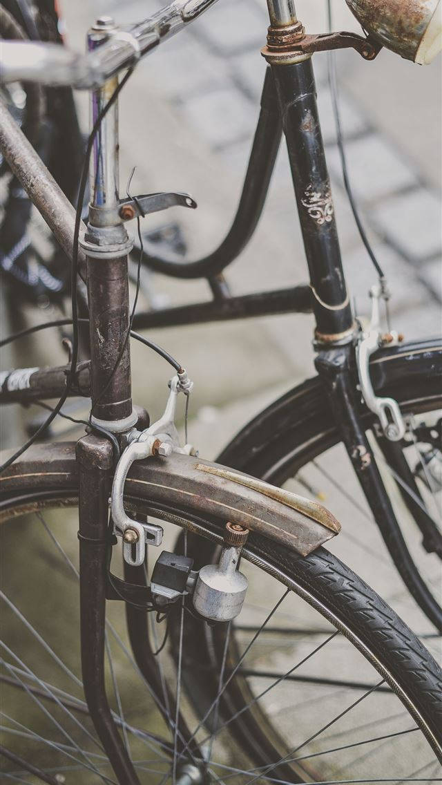 Bicycle 桌布 壁紙 — 鵝卵石街道上復古單車前輪和把手嘅特寫，顯示生鏽嘅金屬同磨損嘅零件。