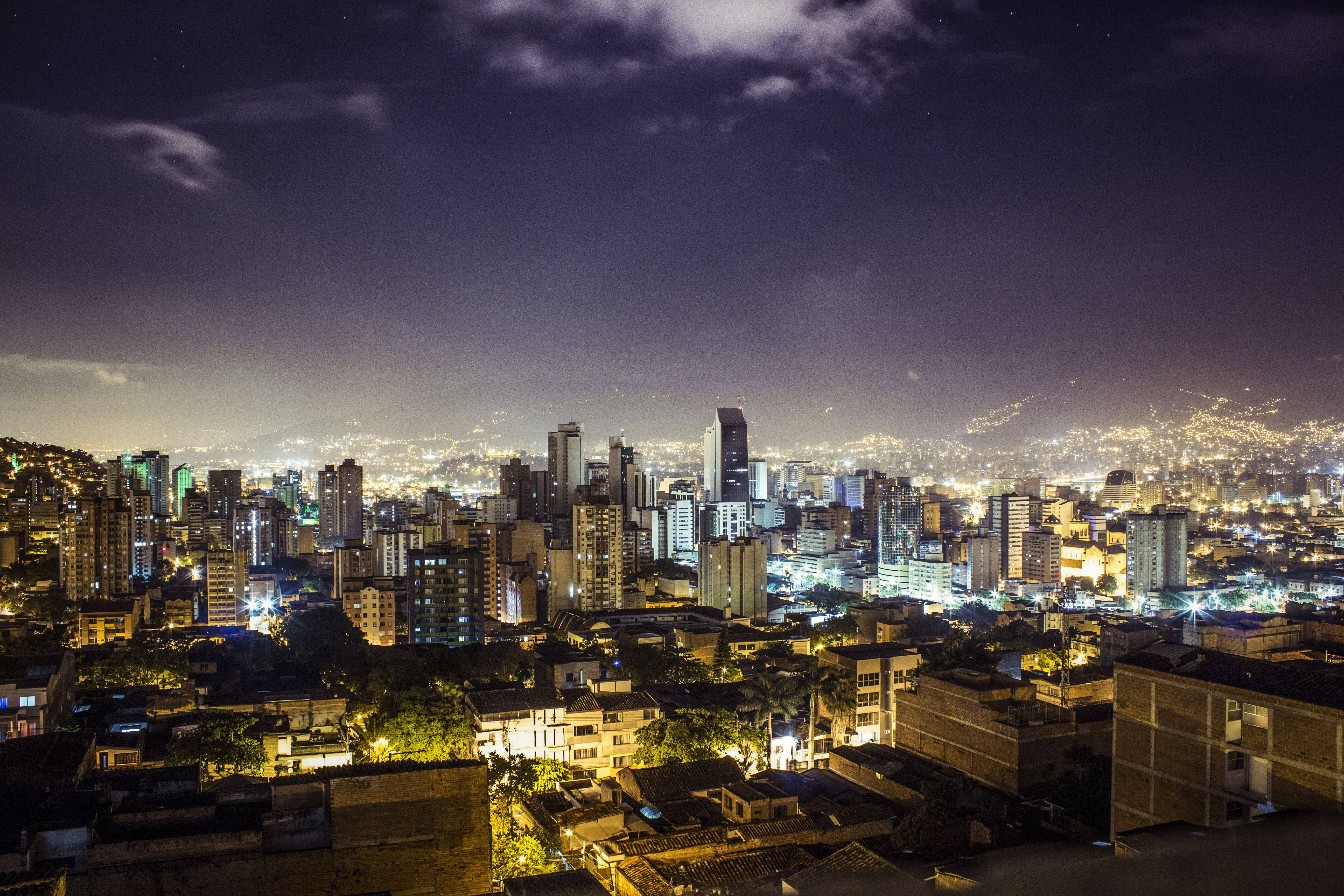 麥德林城市夜景 壁紙 — 繁星點點的天空下，閃爍的摩天大樓和密集的住宅區構成的廣闊城市夜景。