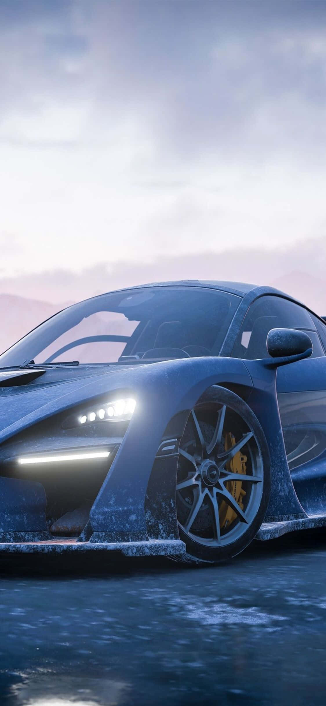 麥拉倫720s iPhone X《極限競速7》背景 壁紙 — 一輛時尚的藍色跑車帶有發光的車頭燈，停在潮濕的道路上，天空是柔和的黃昏色調。