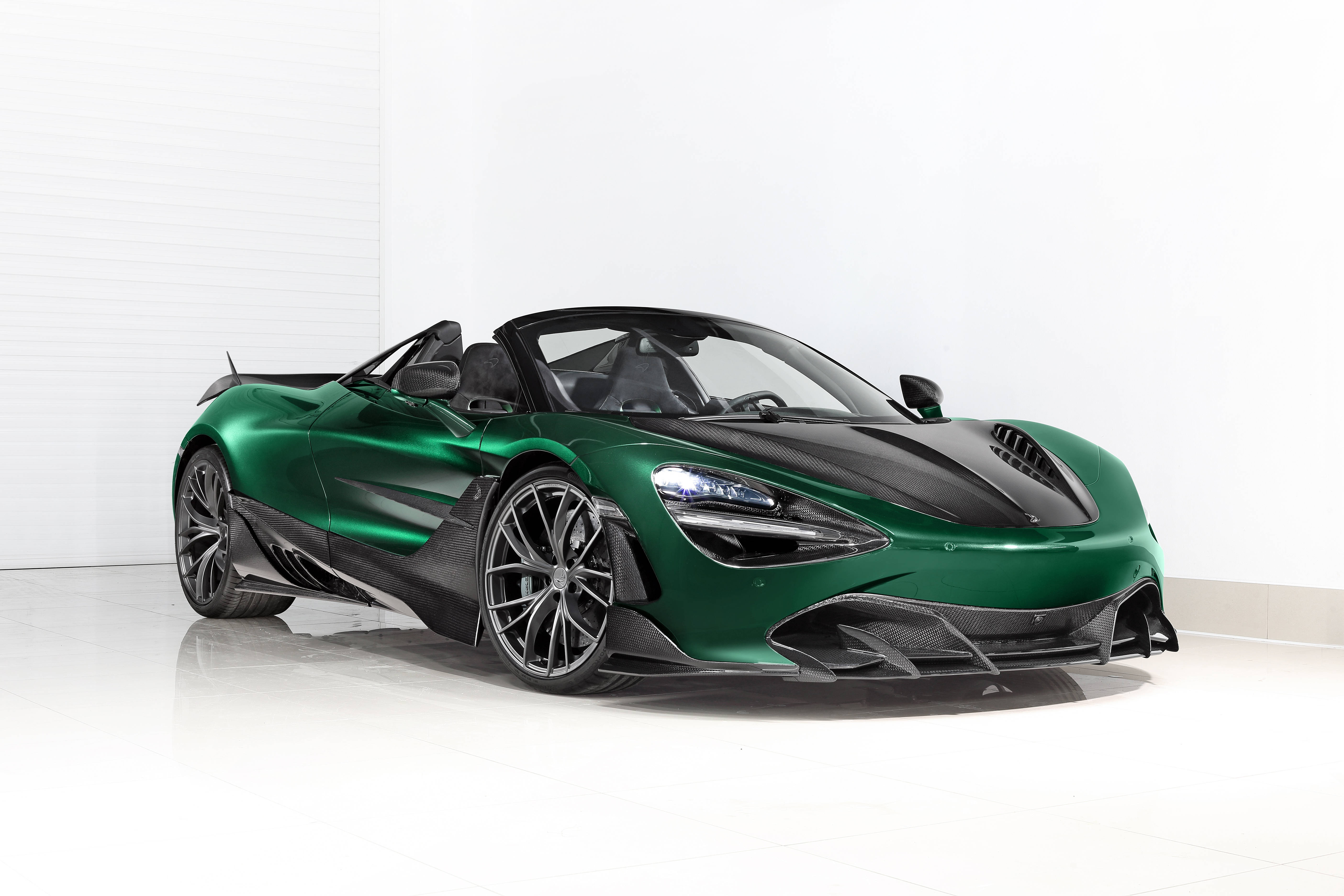 麥拉倫720S 綠色 壁紙 — 一輛時尚的綠色McLaren Speedtail敞篷跑車，帶有黑色碳纖維飾邊，在工作室燈光下於純白地板上閃閃發光。