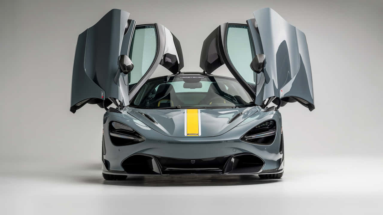 麥拉倫720S經典風采 壁紙 — 一輛時尚的灰色McLaren跑車，帶有黃色條紋和打開的蝴蝶門，在極簡的白色工作室背景前擺拍。