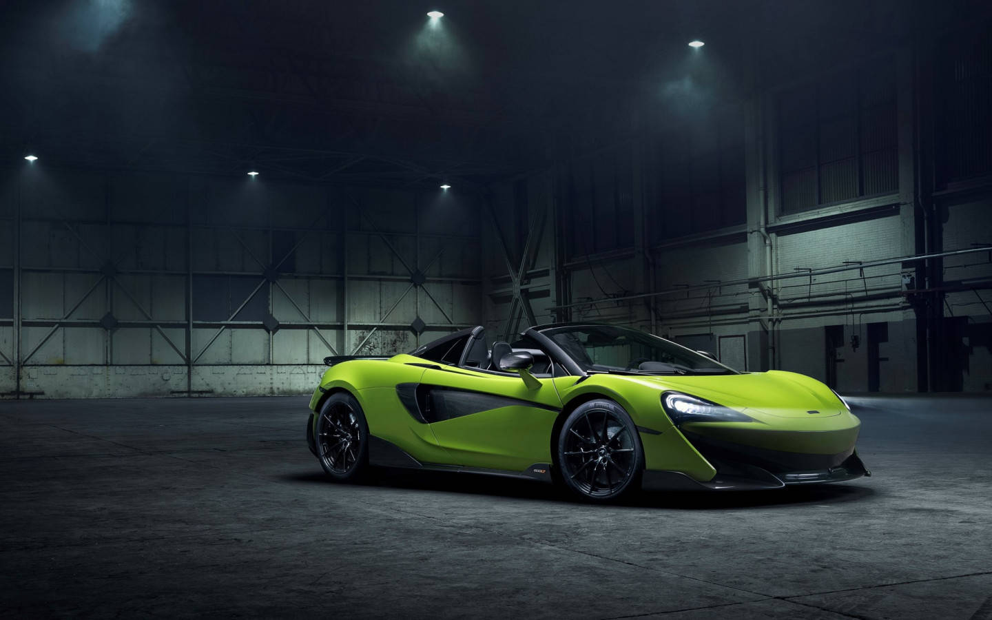 在黑暗工業倉庫中，聚光燈下的青檸綠色McLaren跑車。