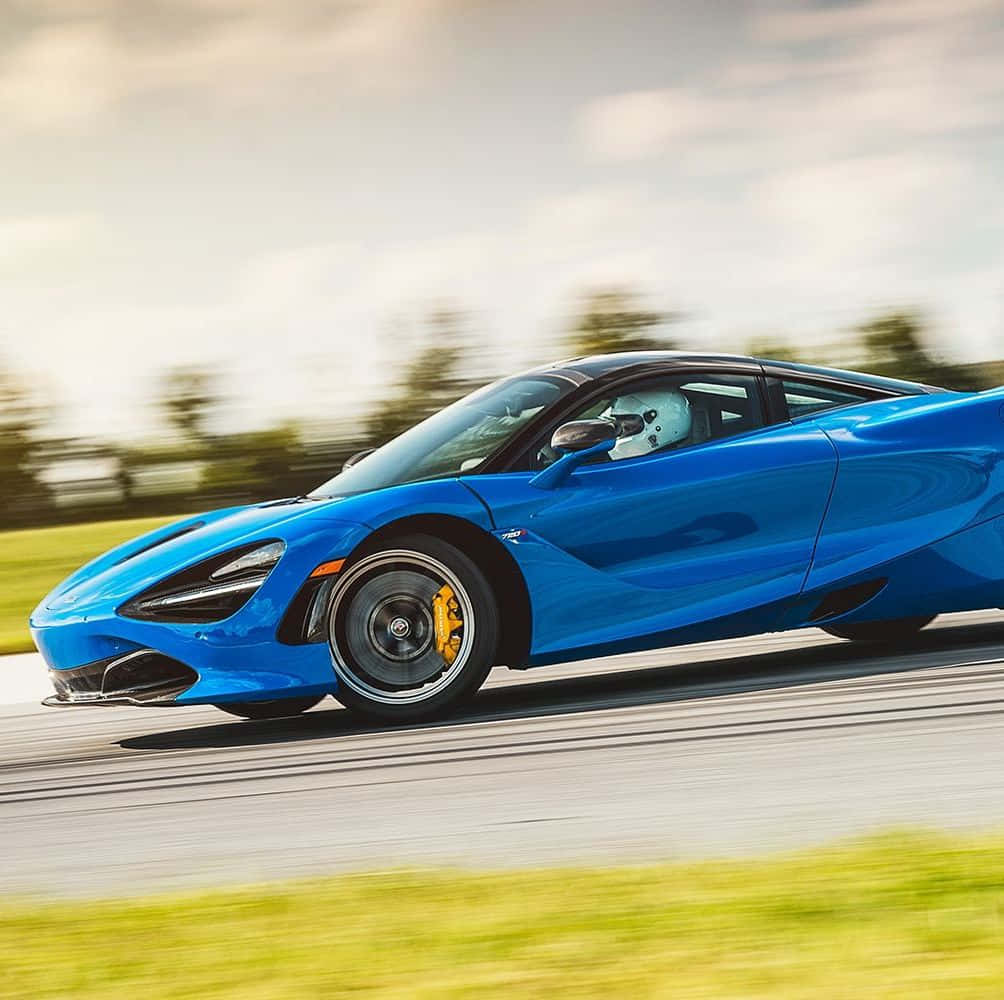 一輛藍色McLaren 720S在道路上疾馳，背景模糊。