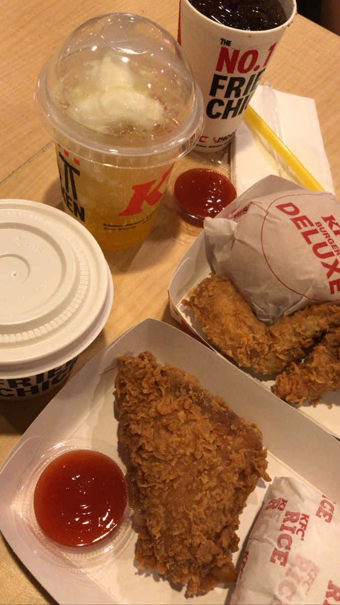 麥當勞雞肉餐托盤圖 壁紙 — KFC香脆炸雞塊和飲品放在木桌上，附有茄汁包的近距離特寫。