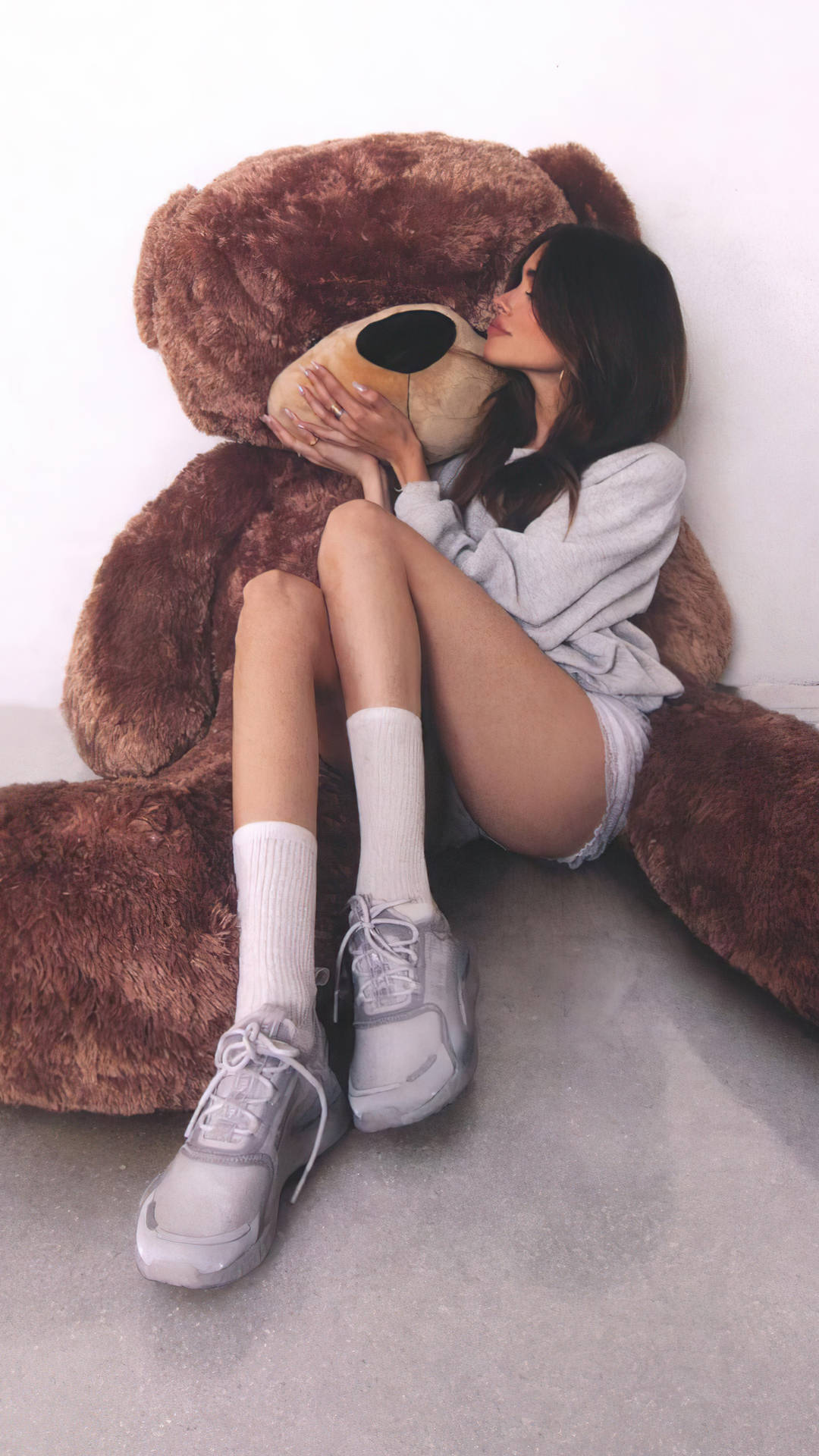 年輕女性在舒適的室內環境中擁抱巨大的泰迪熊。